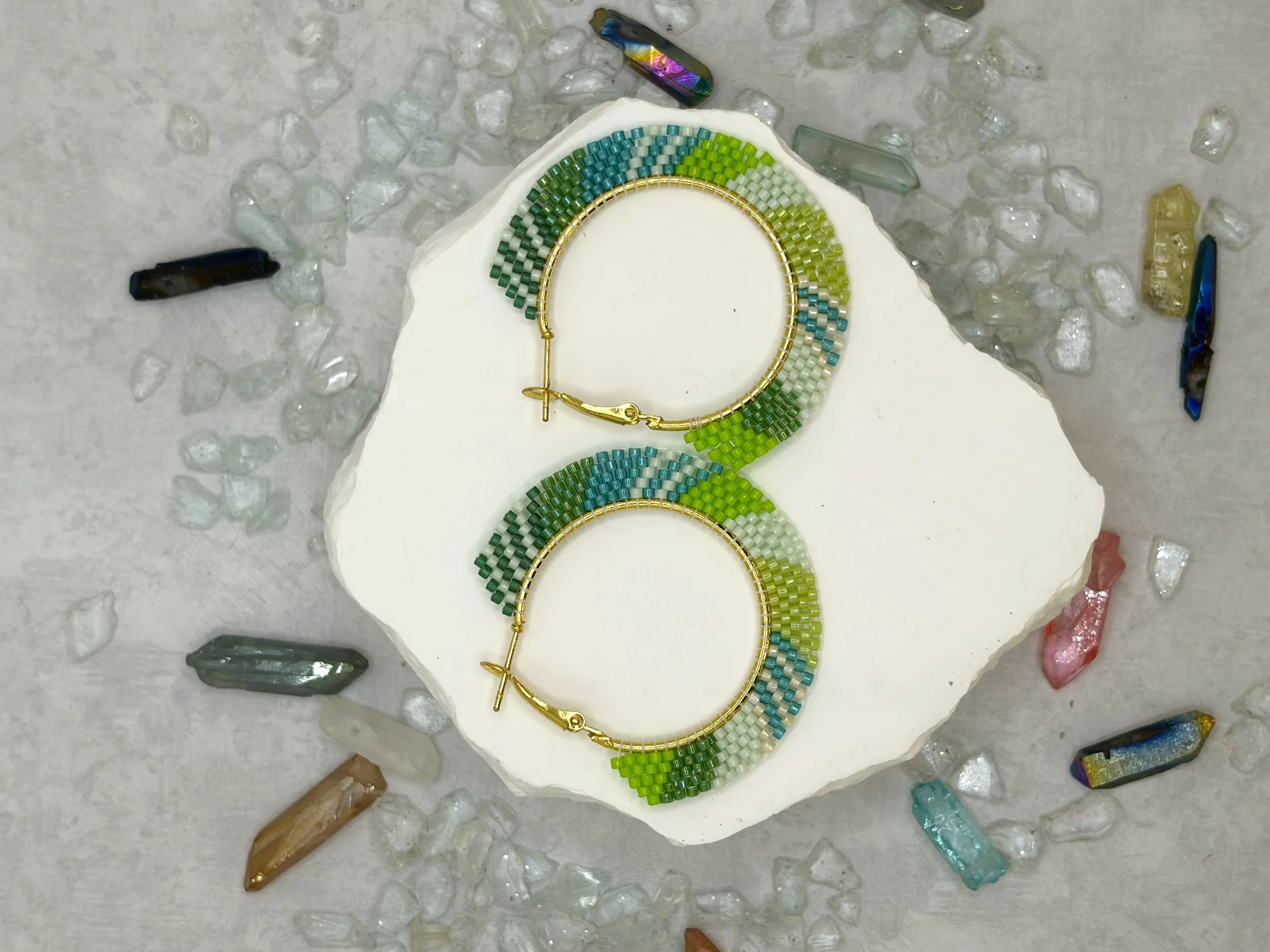 Green, teal, white and lime seed bead woven hoop earrings in gold-tone metal.
