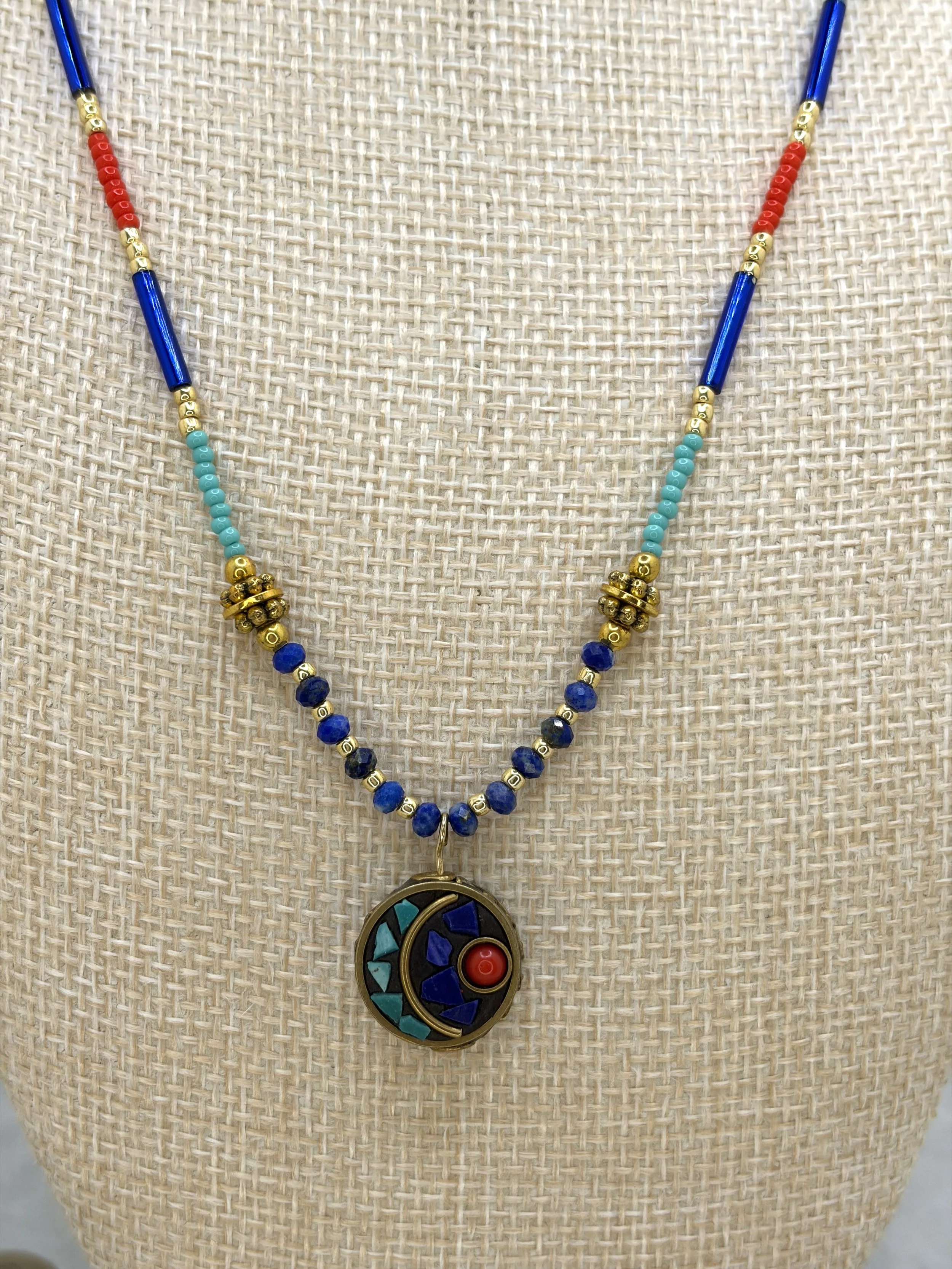 handmade beaded necklace with round Tibetan brass turquoise coral inlay charm and faceted lapis lazuli beads