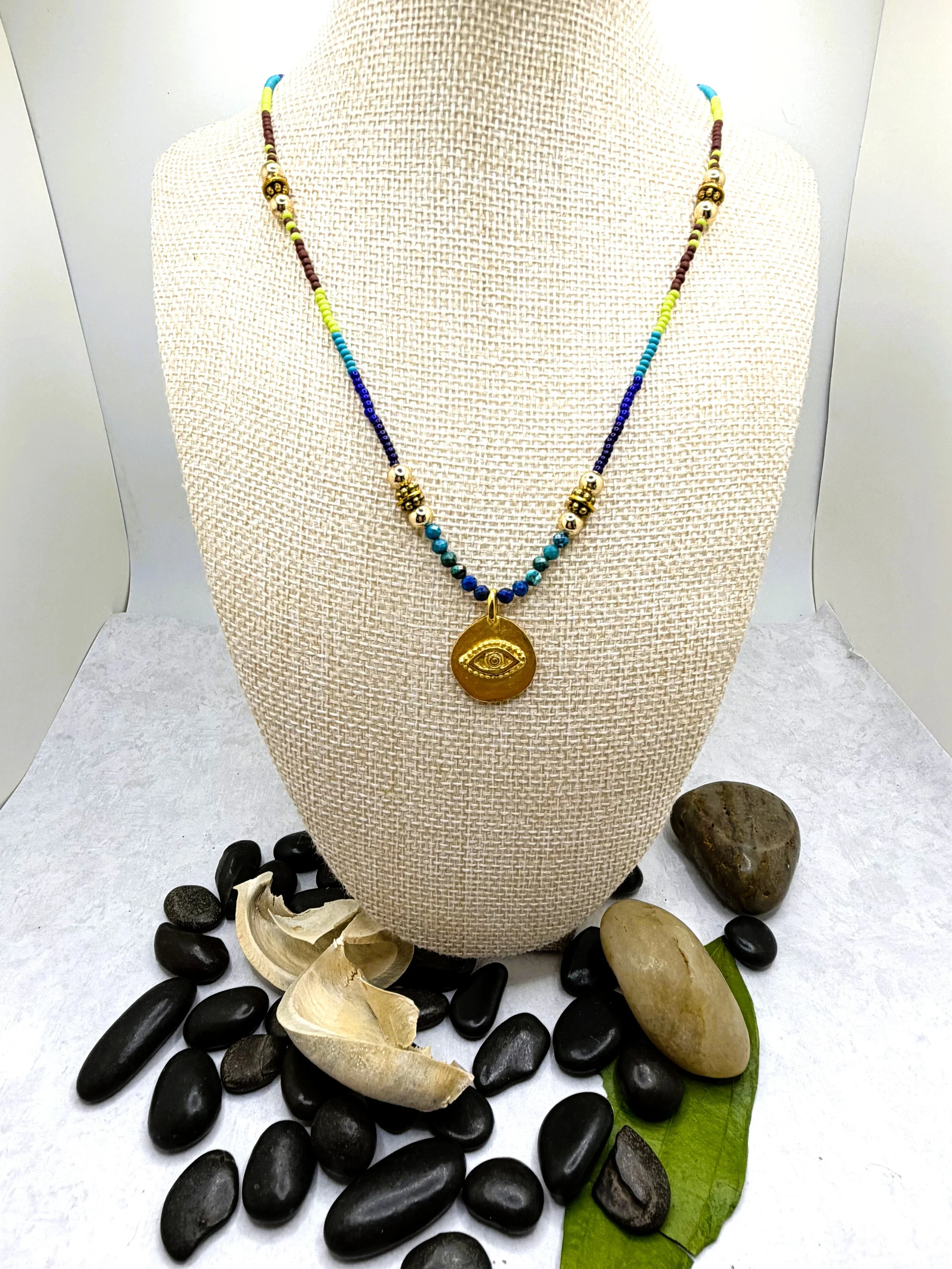 Handmade ombré seed bead necklace with faceted chrysocolla beads and a gold-tone evil eye charm pendant