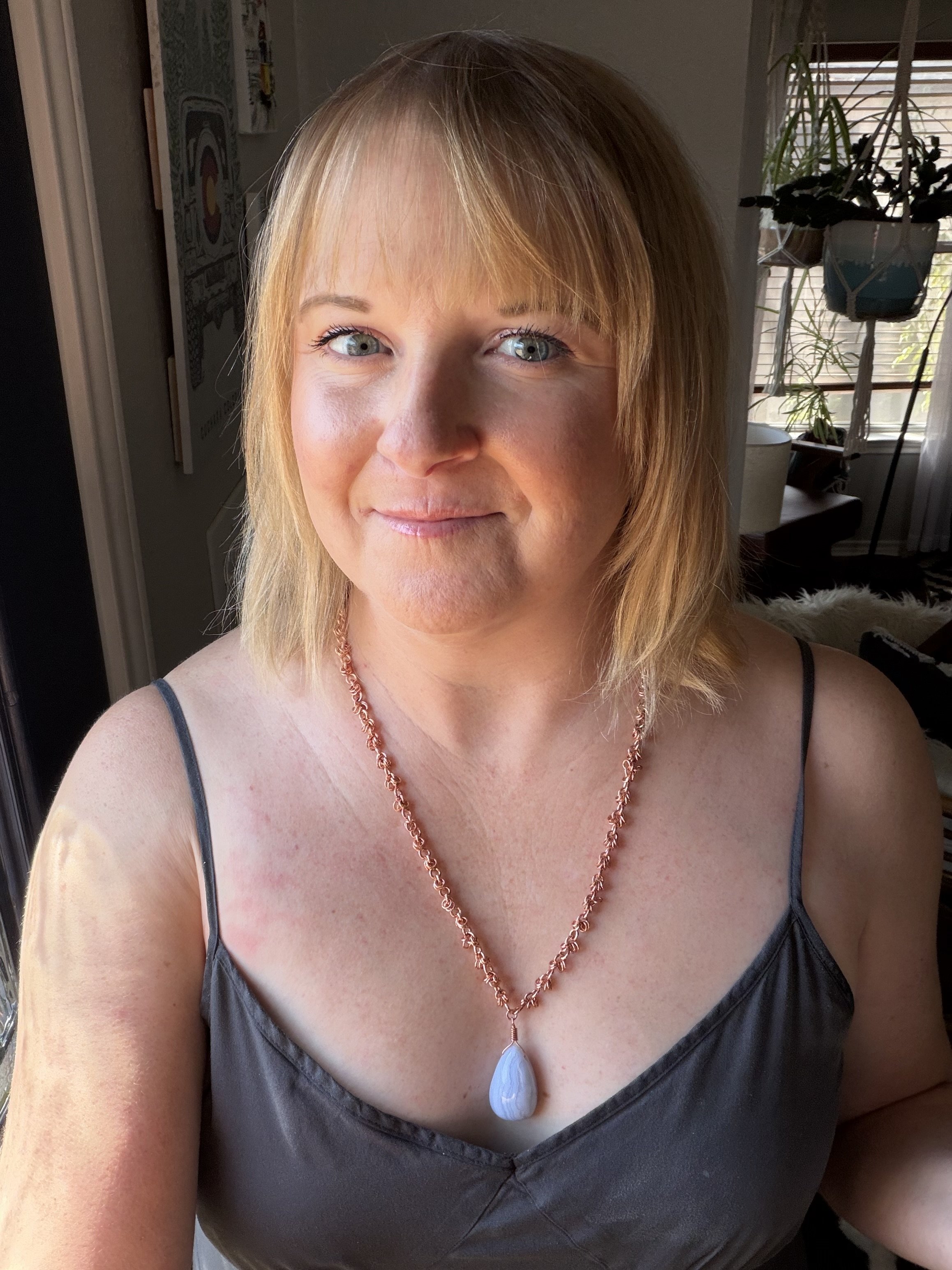 Copper chainmail necklace with a blue lace agate teardrop pendant, worn on model.