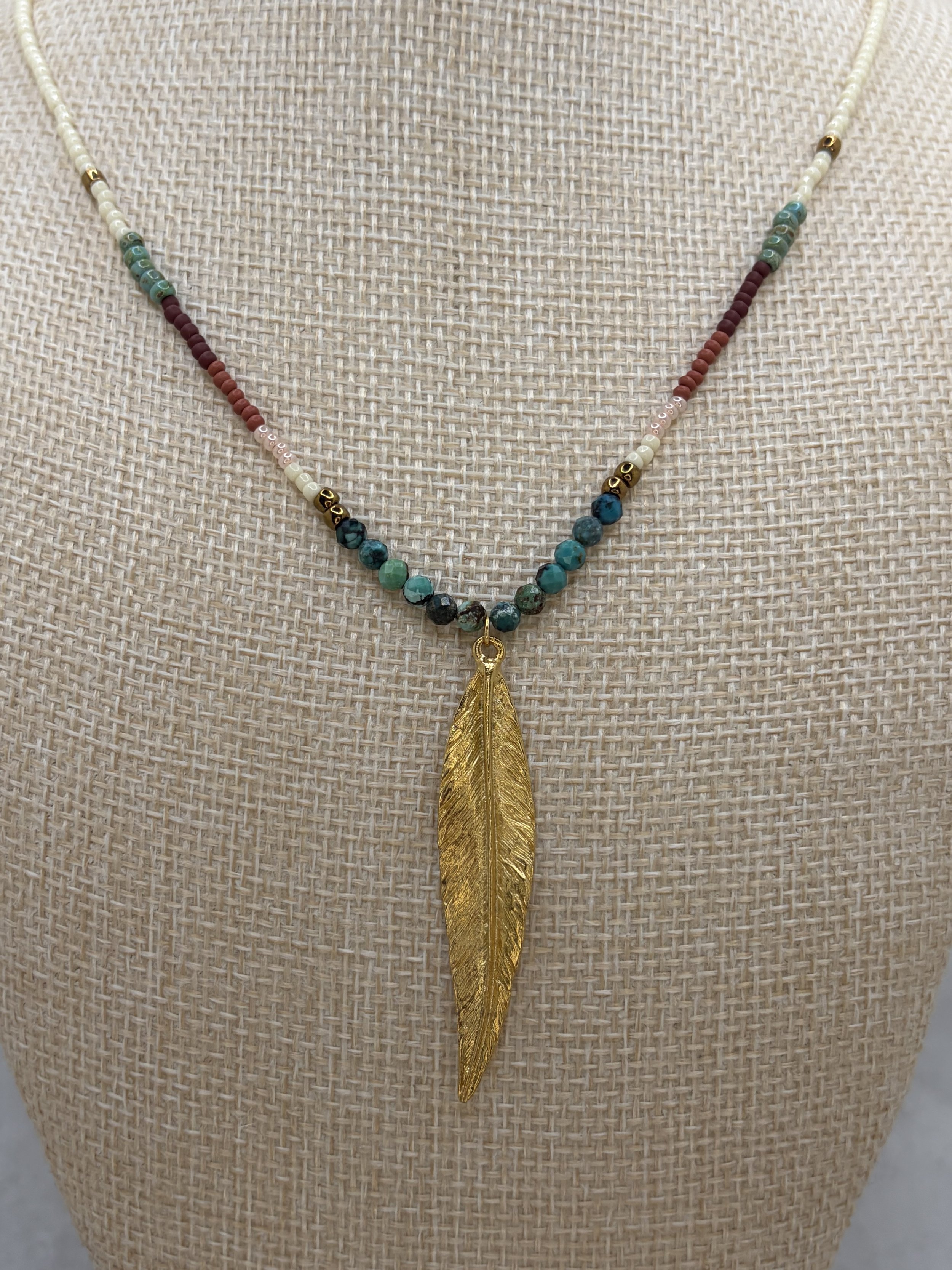 handmade seed bead necklace with turquoise beads and gold stainless steel feather pendant