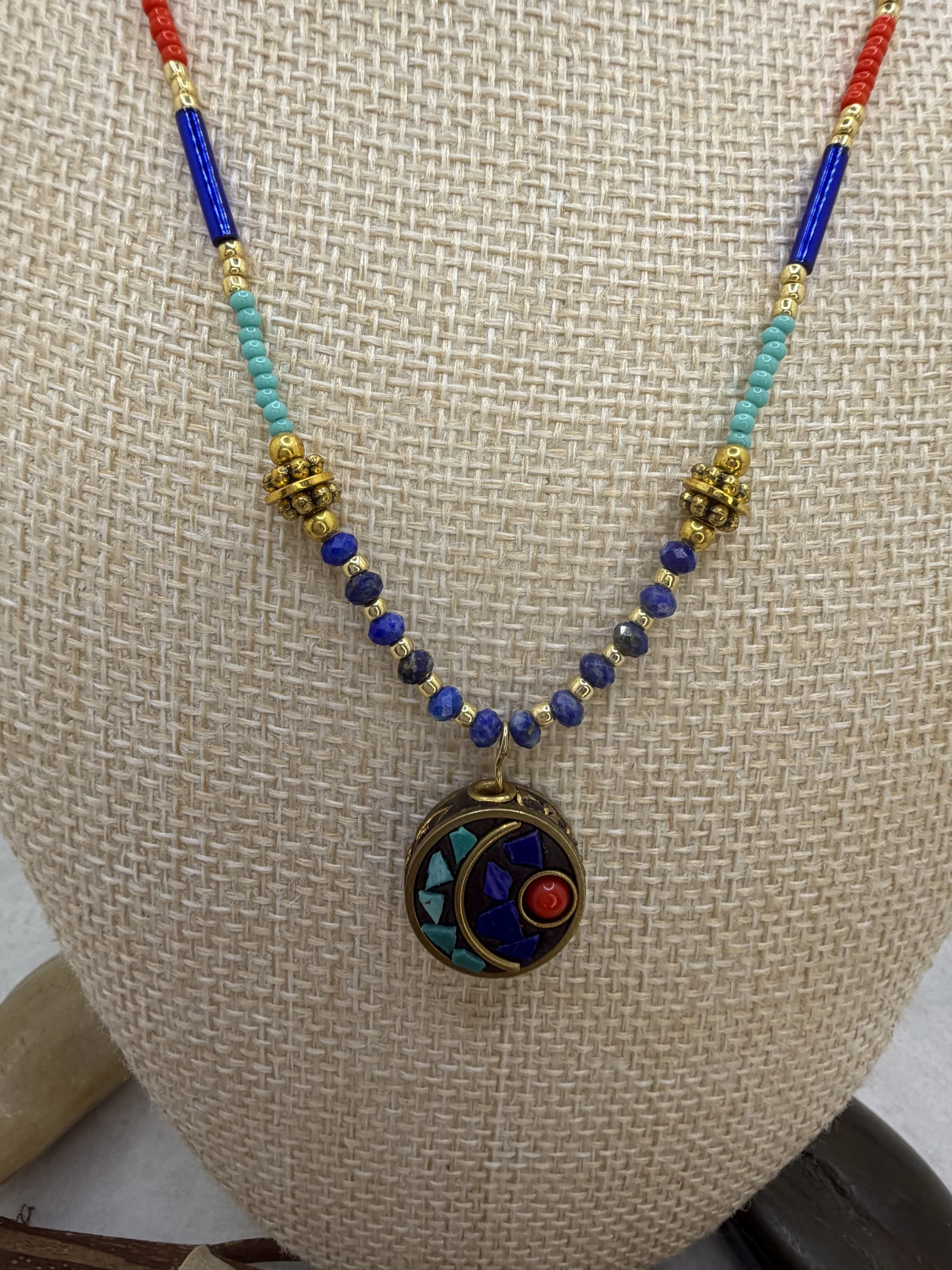 handmade beaded necklace with round Tibetan brass turquoise coral inlay charm and faceted lapis lazuli beads