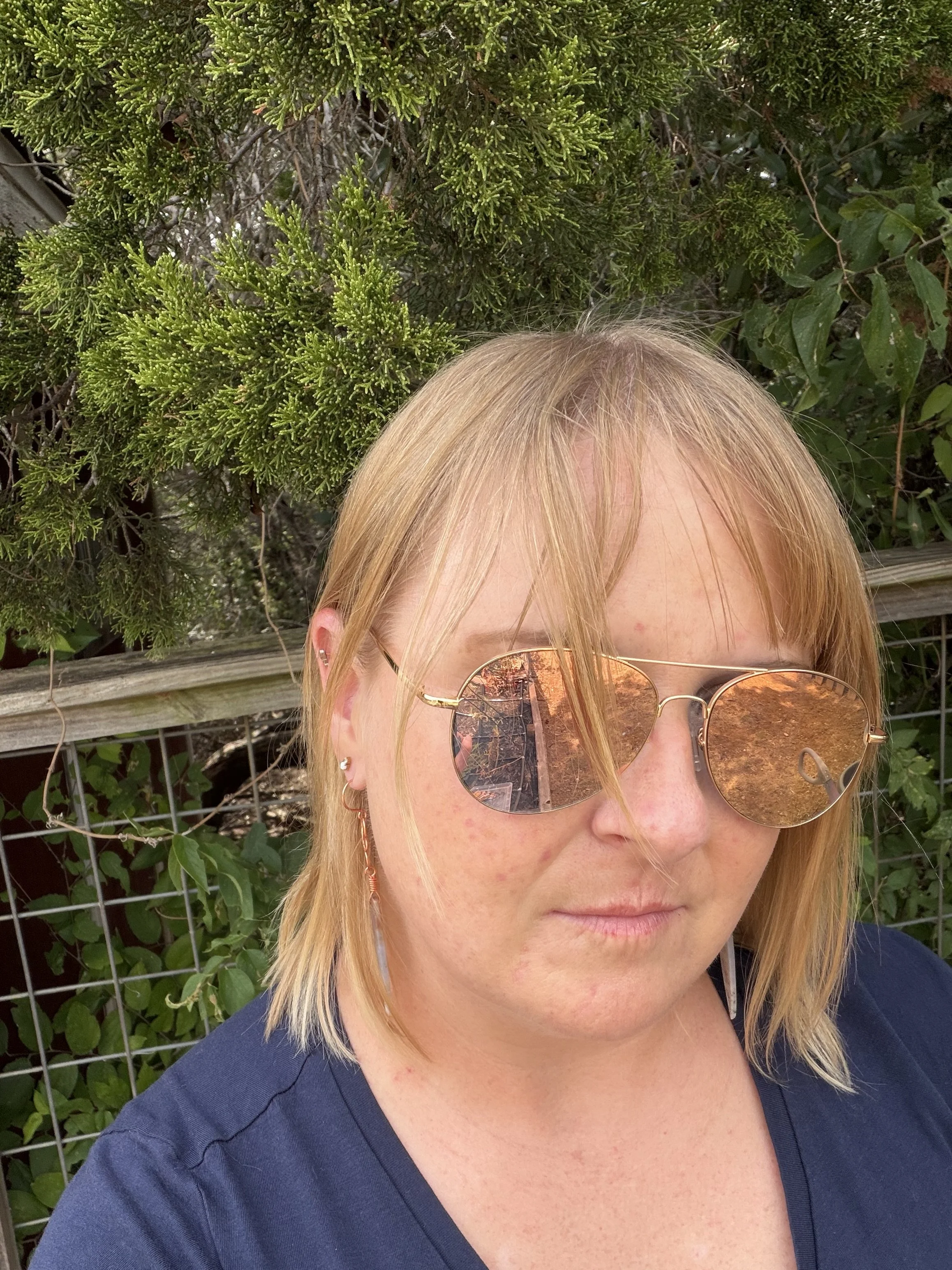 woman wearing handmade ocean jasper copper wire wrapped dagger earrings with copper infinity knot connector