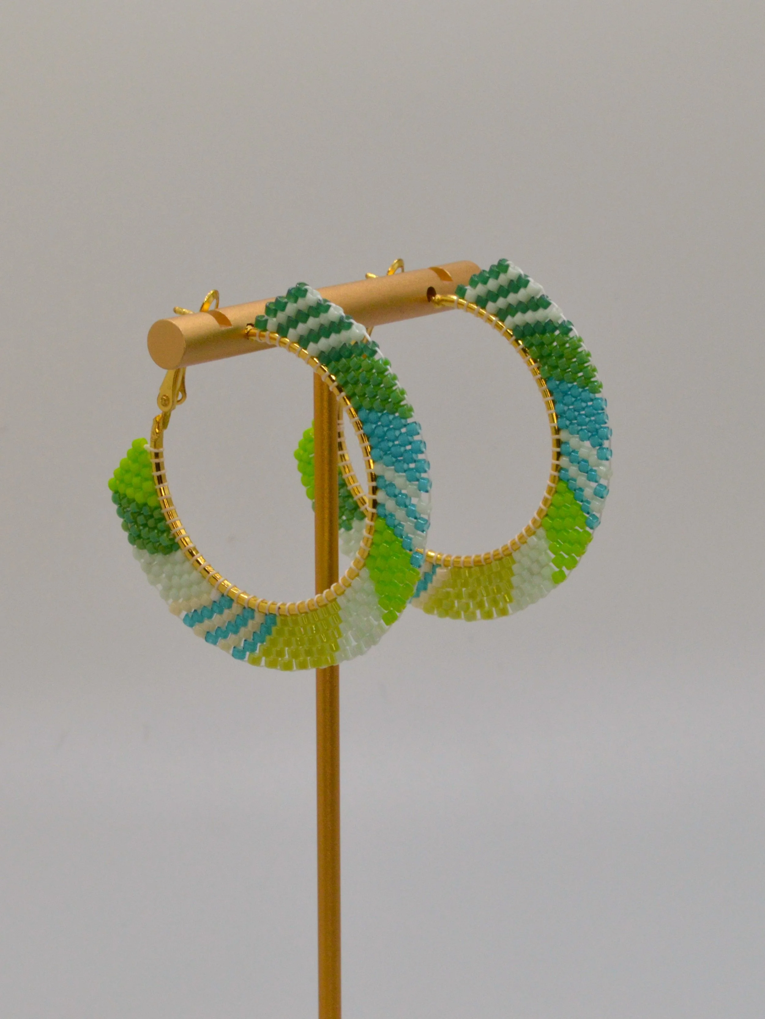 Green, teal, white and lime seed bead woven hoop earrings in gold-tone metal.