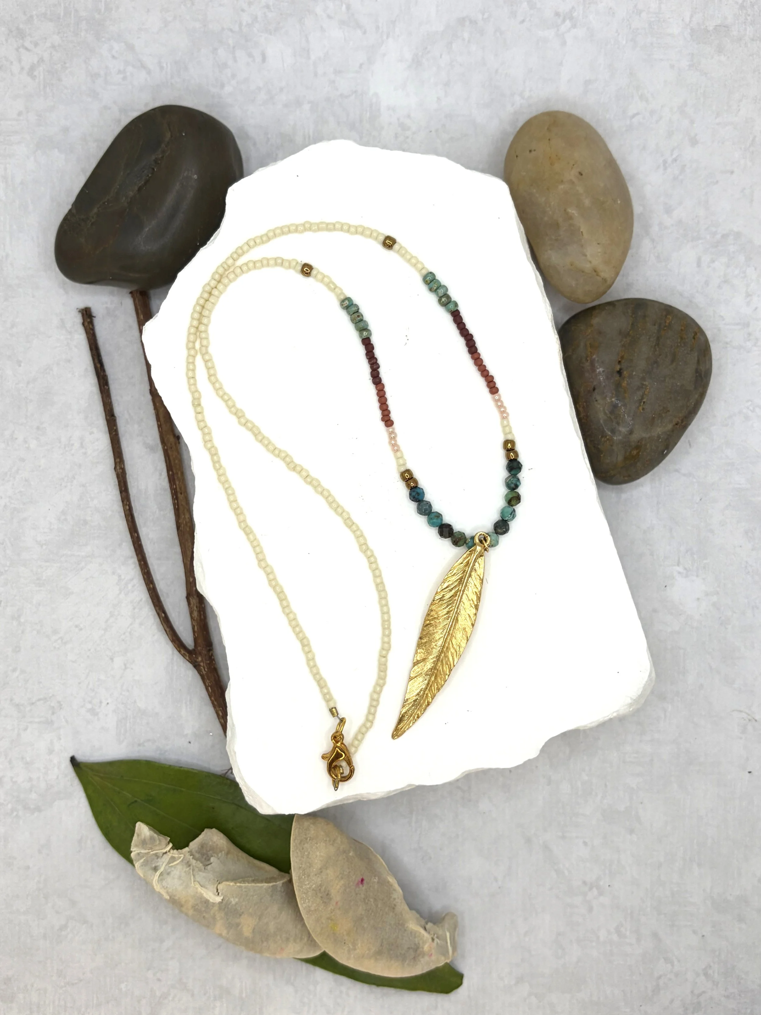 handmade seed bead necklace with turquoise beads and gold stainless steel feather pendant