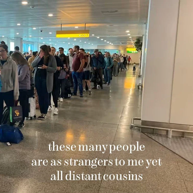 A long line of people at an airport terminal, waiting with luggage. The scene is indoors with bright lighting and signs overhead, and overlaid with the short poem: 'these many people are as strangers to me yet all distant cousins.'