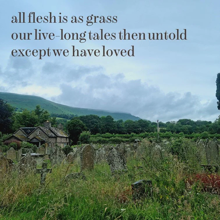 A graveyard with weathered tombstones overgrown with grass and weeds, surrounded by lush green trees and rolling hills in the background. The sky is cloudy, and there is a house visible to the left. Text overlay reads: "all flesh is as grass our live-long tales then untold except we have loved."