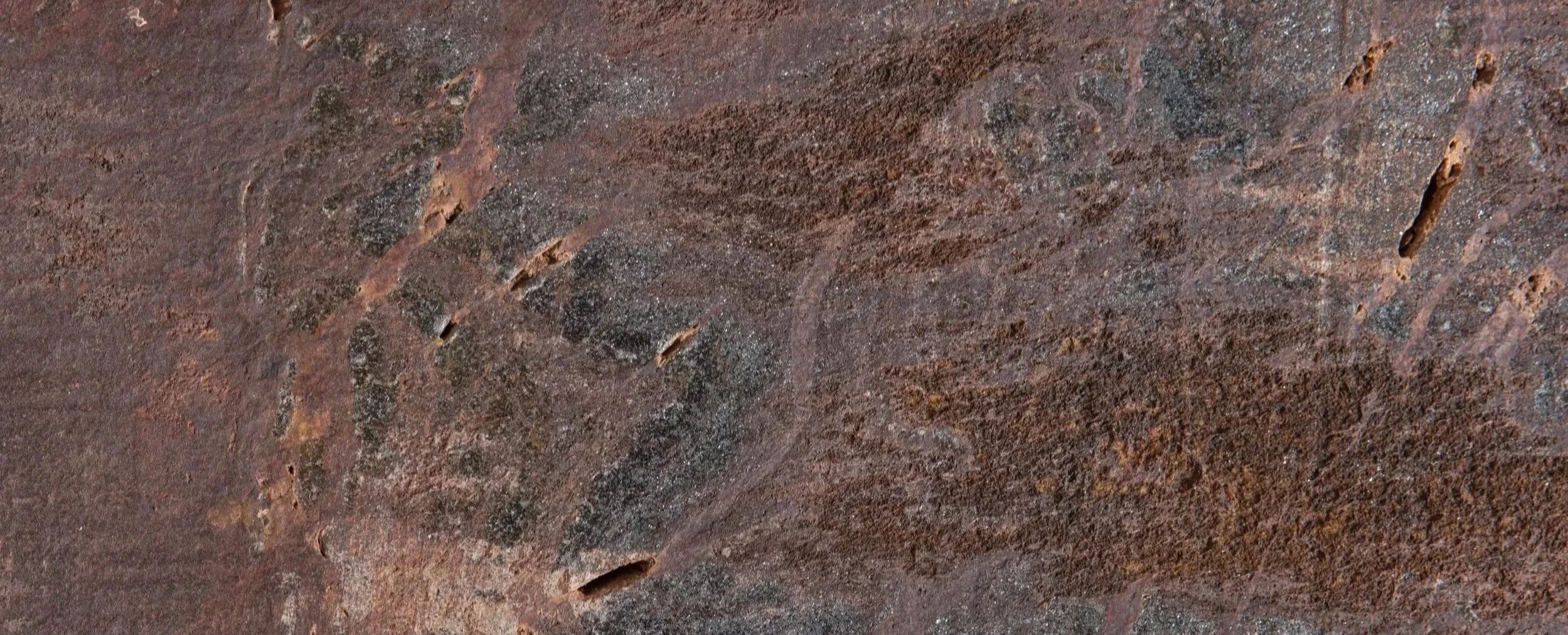 Superfície de pedra de cor marrom com textura áspera e veios naturais