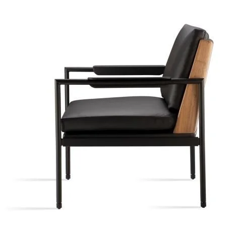 Poltrona moderna com estrutura de metal preta, assento e encosto acolchoados em couro preto, e detalhes de madeira na parte traseira do encosto.