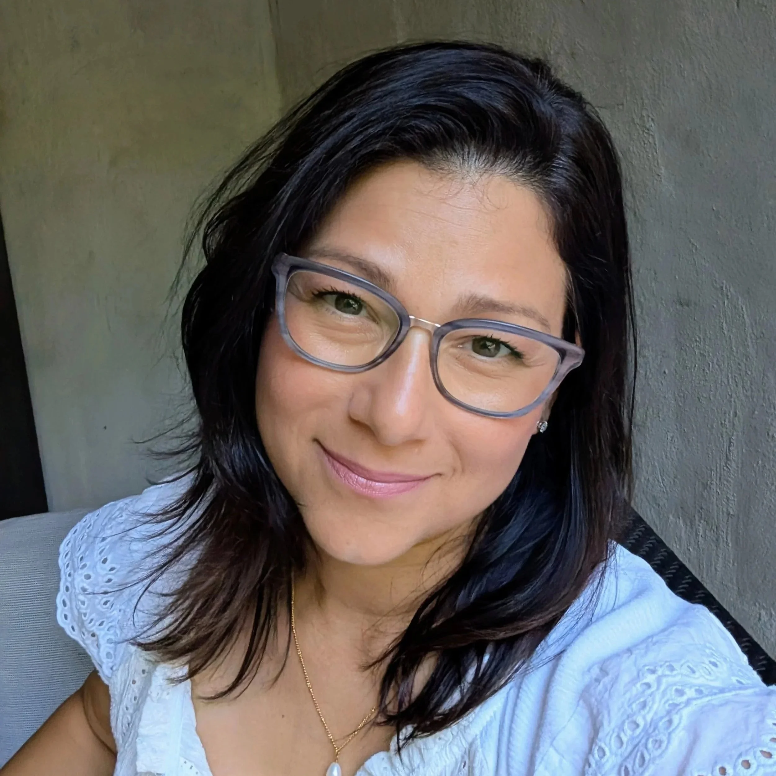 Disa Almeida smiling in glasses and a white blouse