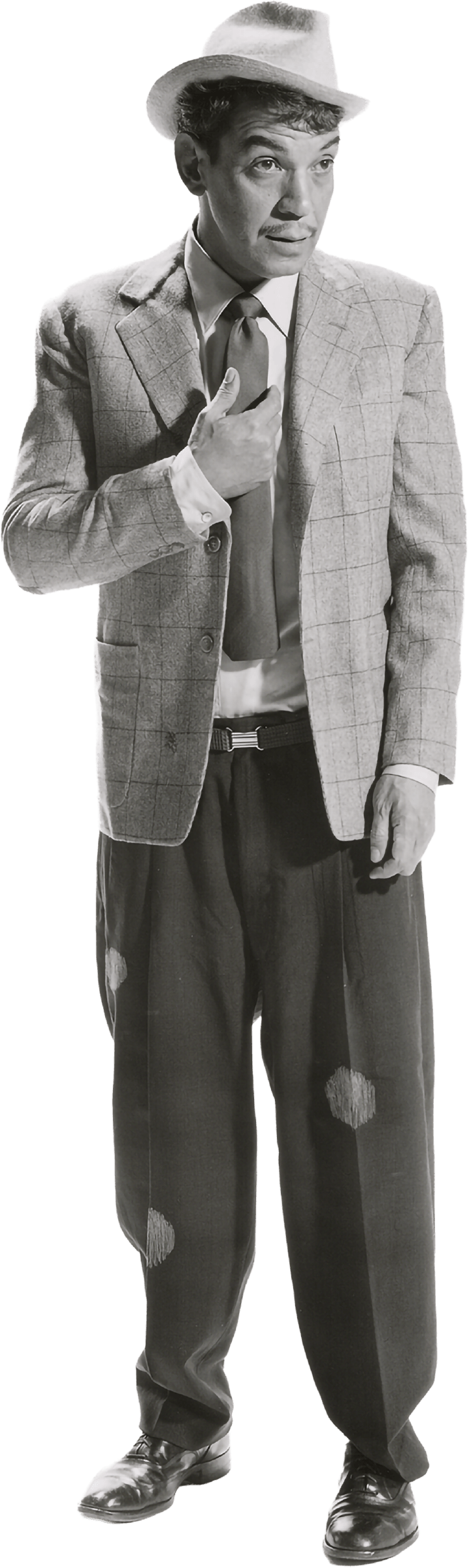 Cantinflas con sombrero, saco a cuadros, camisa blanca, corbata y pantalones anchos con parches, ajustados con zapatos formales. Señalándose a él mismo a la alatura del pecho.