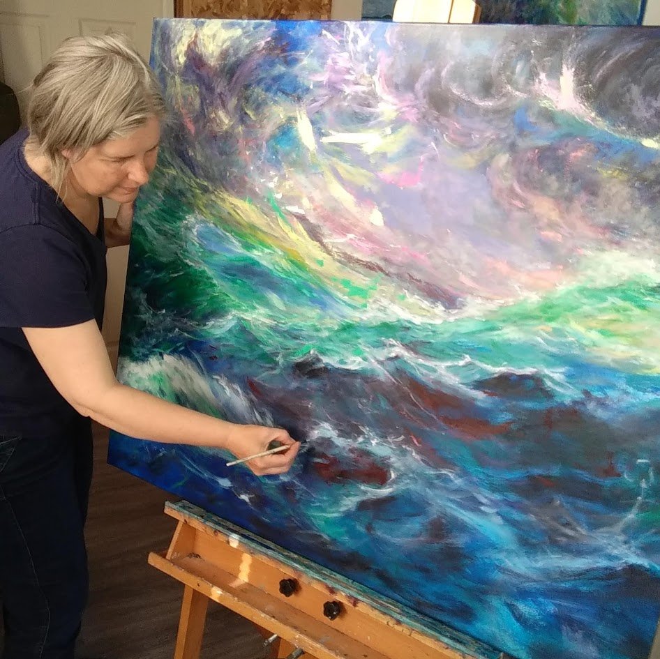 Jill is using a paintbrush and adding detail to a large seascape