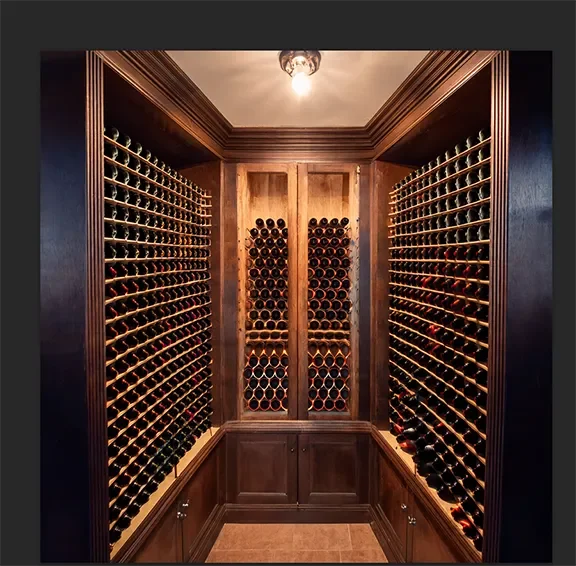 A cozy wine cellar for a small backyard dwelling unit with dark wood cabinetry, featuring rows of wine bottles.