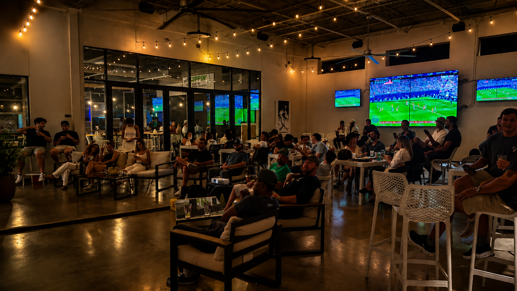 Guests enjoying a watch party on Hoppin' Gulch patio, Nashville's self-pour taproom with duckpin bowling, craft beer, cocktails, and large-screen TVs.