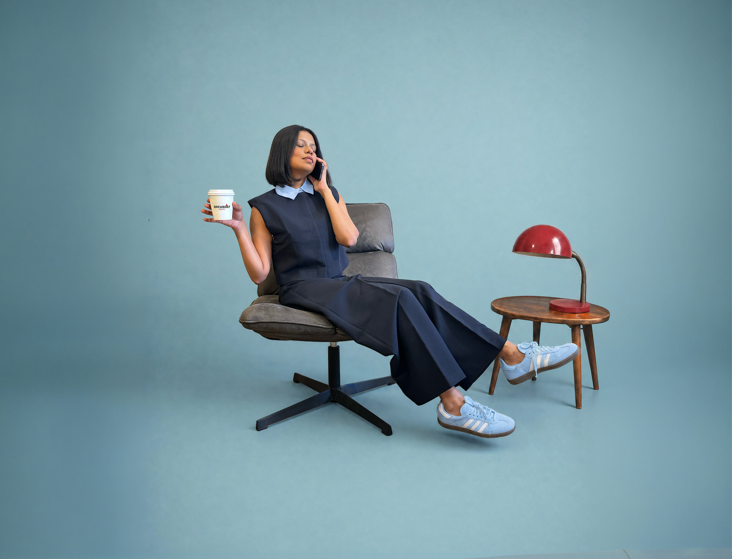 Woman relaxing with a Brewboat chai while talking on the phone.
