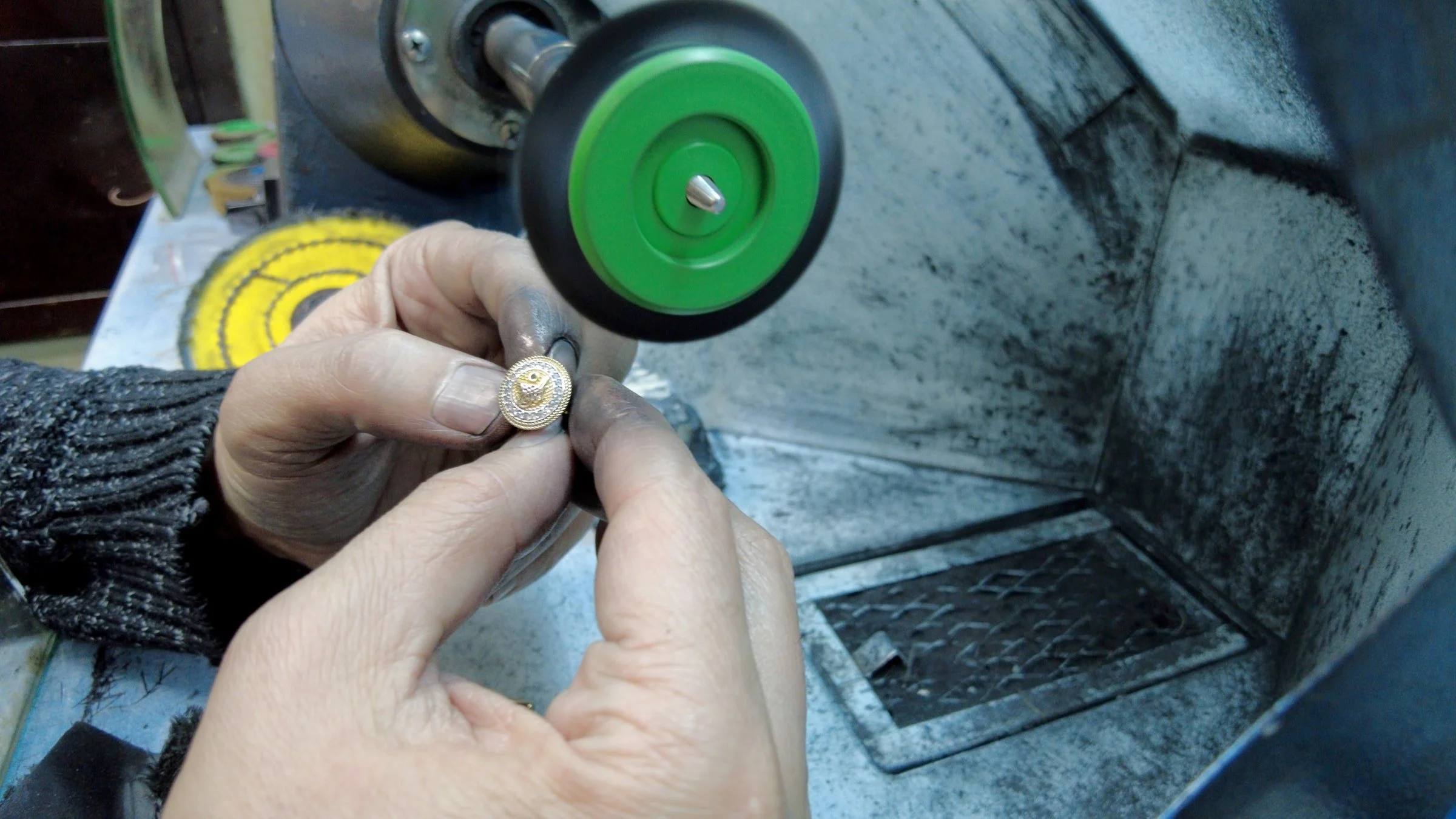 Jeweler polishing a ring at a workshop polishing wheel