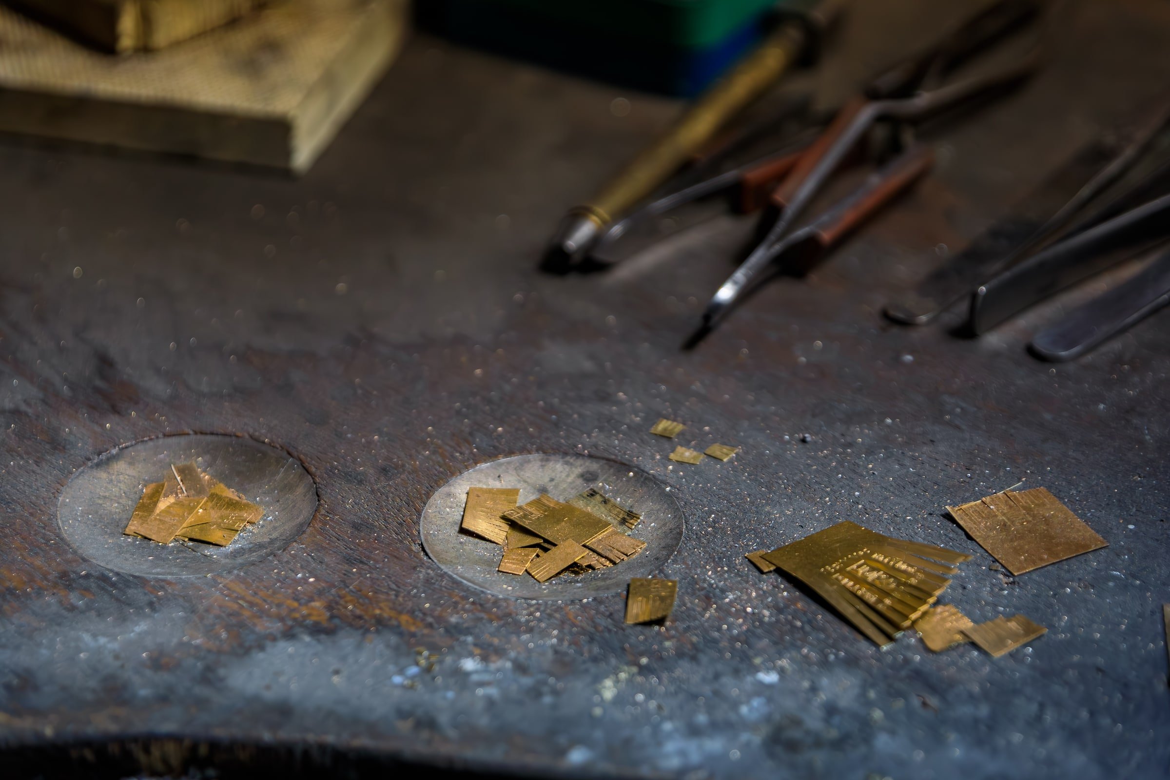Small jewelry metal offcuts and scrap on a jeweler’s workbench
