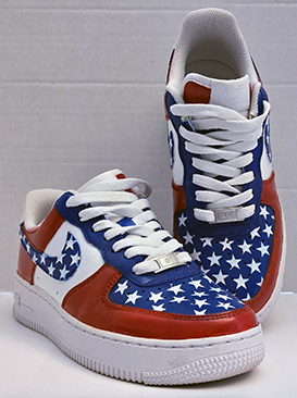 Pair of sneakers decorated with American flag stars and stripes, featuring red, white, and blue colors, against a plain background.
