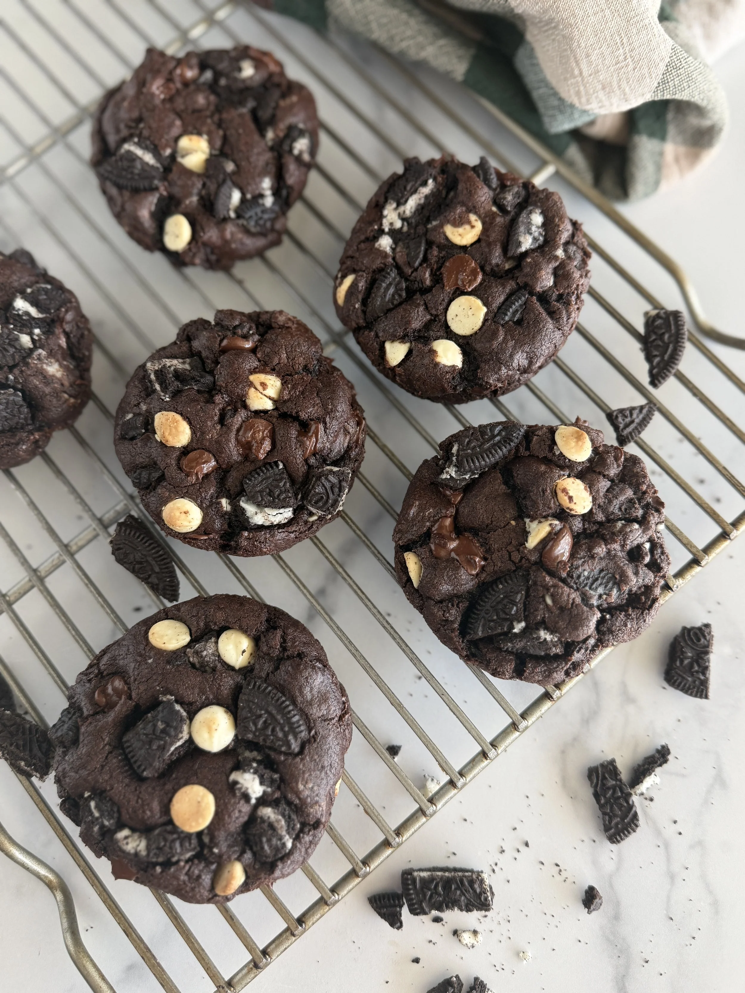 Chocolate oreo cookies on a cooling rack.