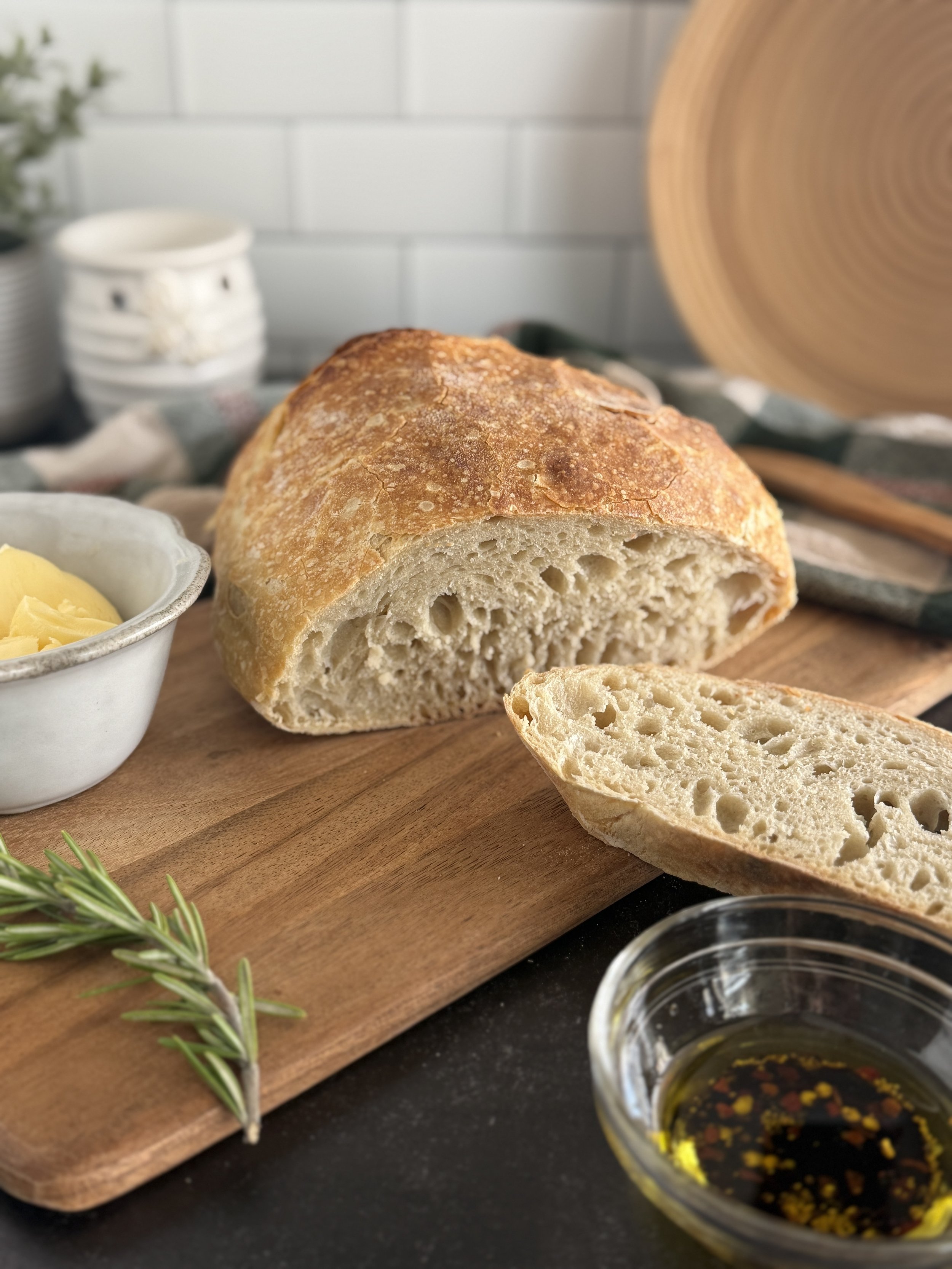Close up of a crusty bread loaf with one slice of bread cut off from it.