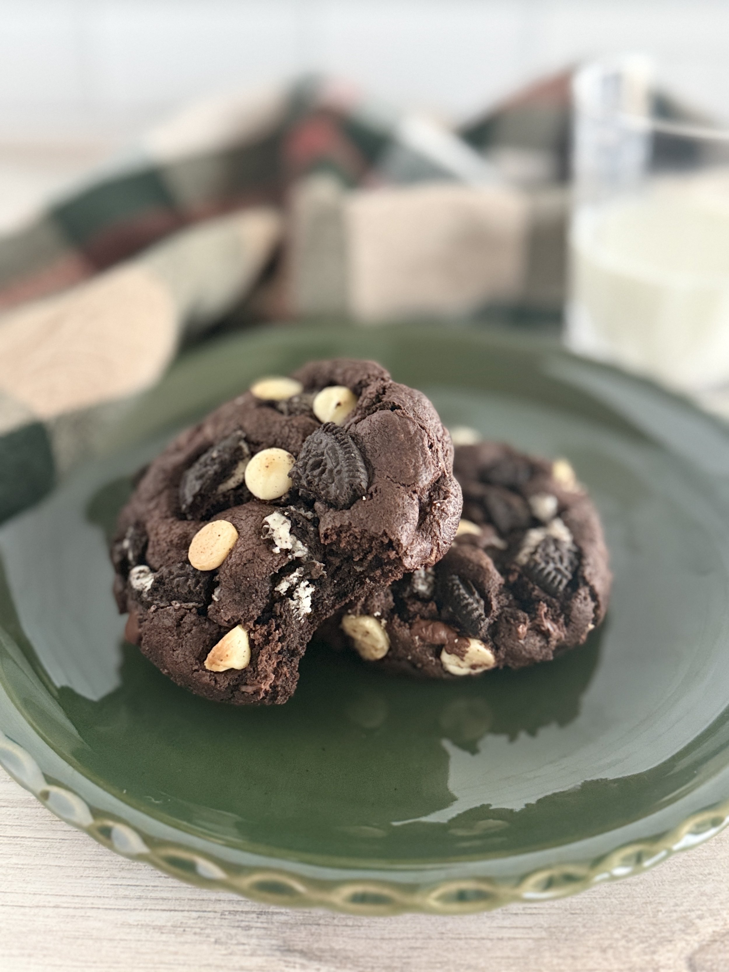 Two chocolate oreo cookies on a green plate.