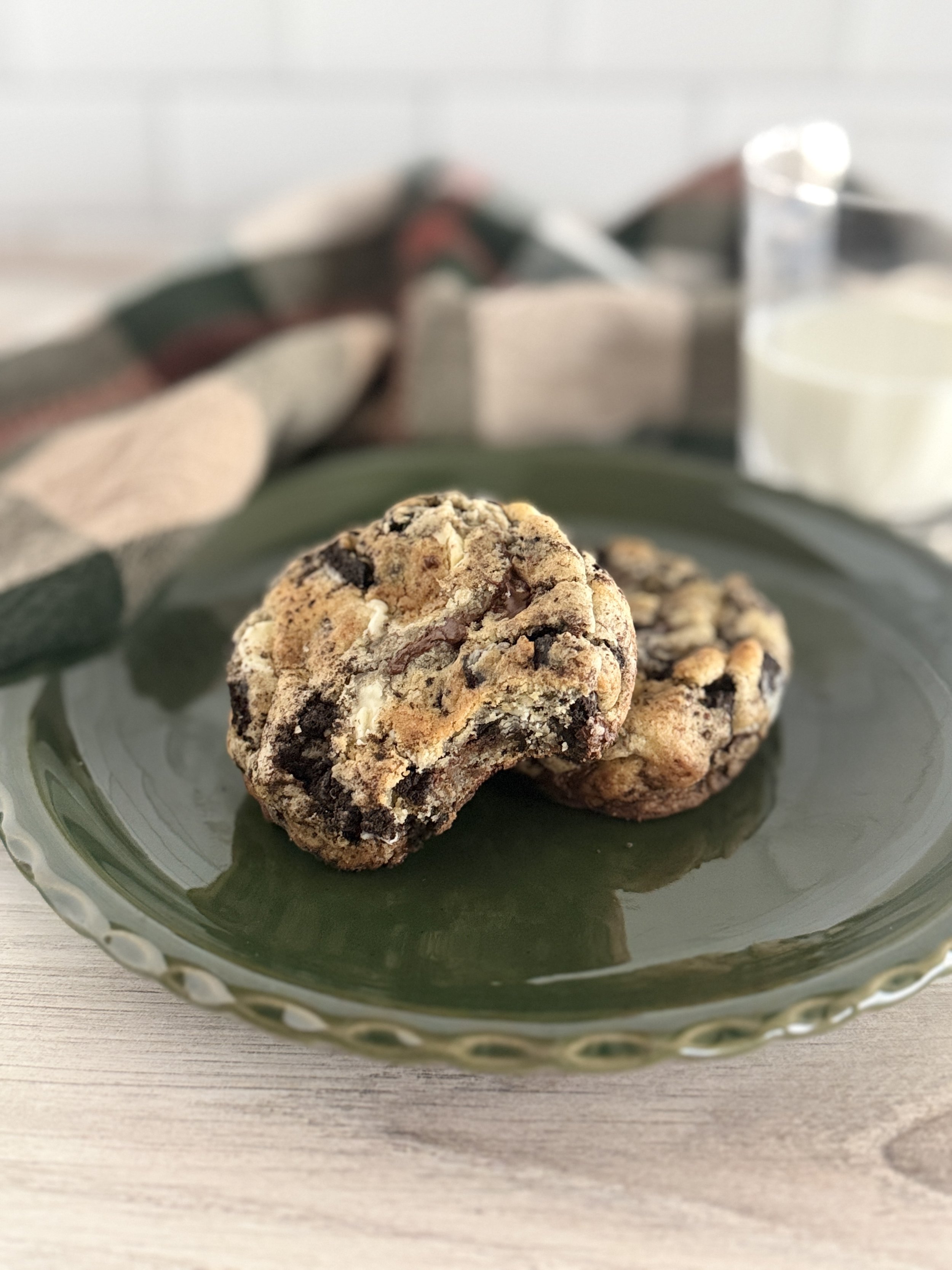 Two oreo cookies on a green plate.