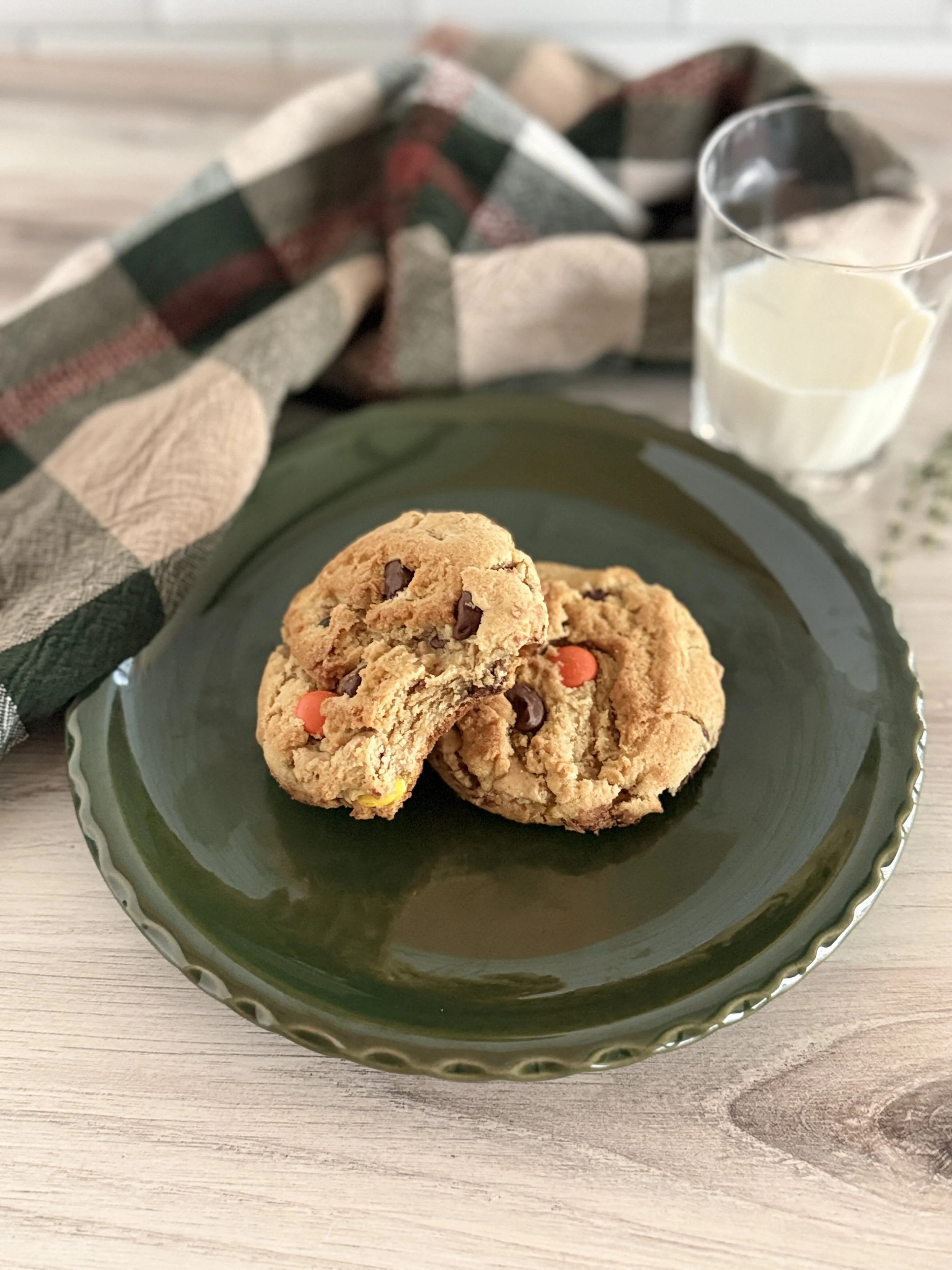 Two Reece's peanut butter cookies on a green plate.