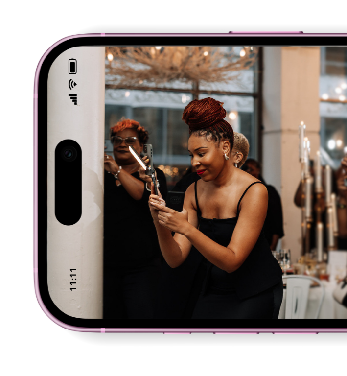 Kia Holt, founder of Ms. Digital on Demand, is in action, creating dynamic social media content at a wedding in an elegant black dress.