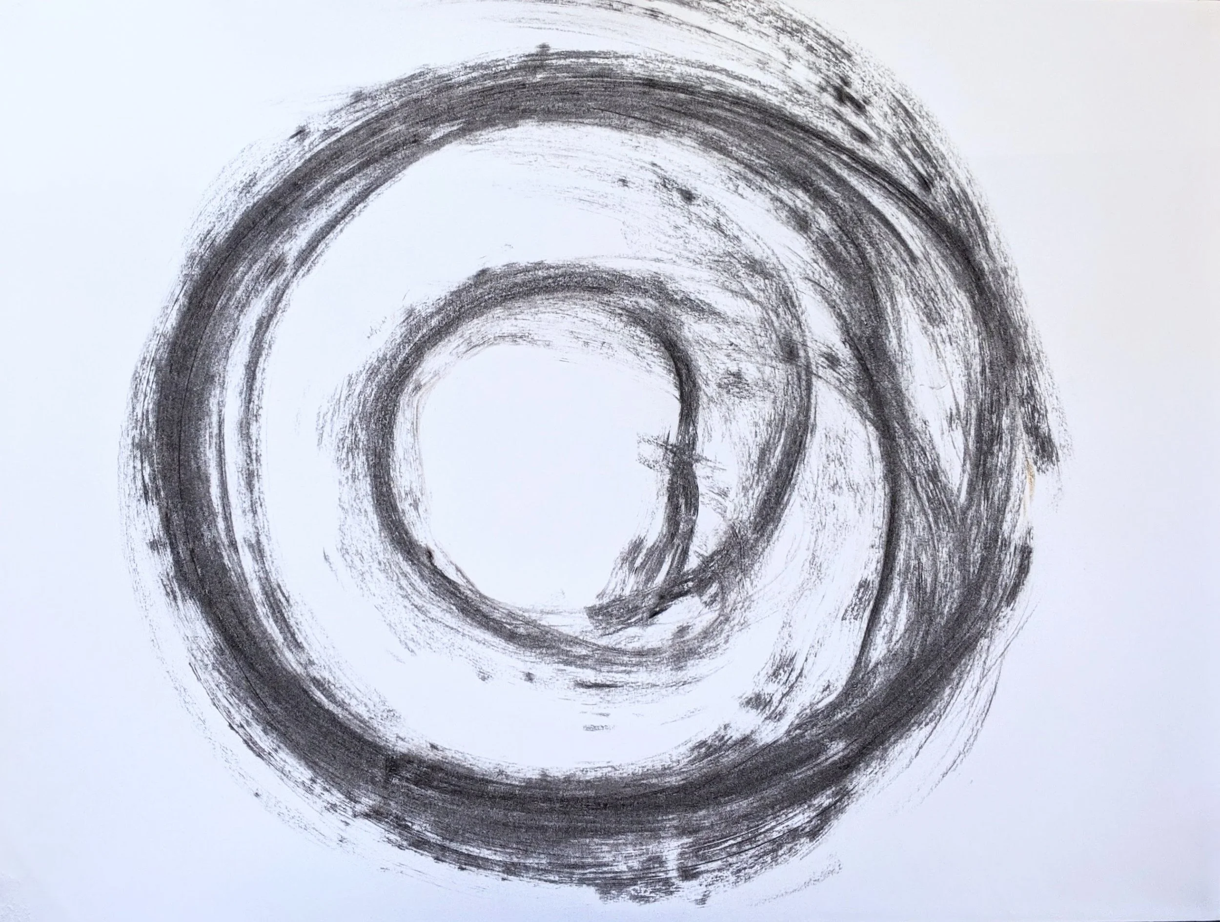 Black charcoal concentric circles drawn on white paper.