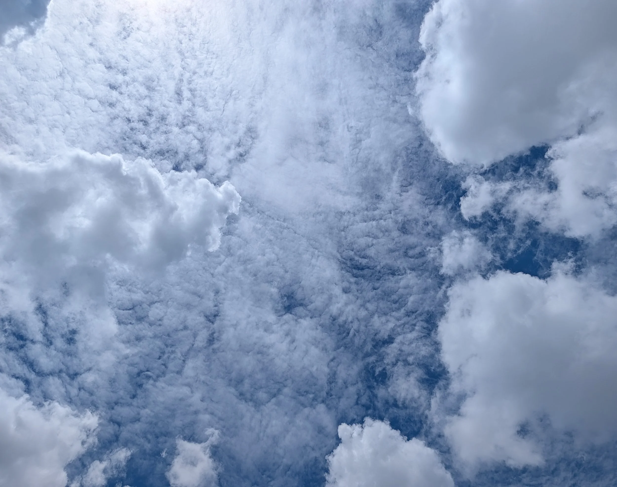 Cloud study: Cloudy sky with patches of blue and various formations of white and gray clouds.