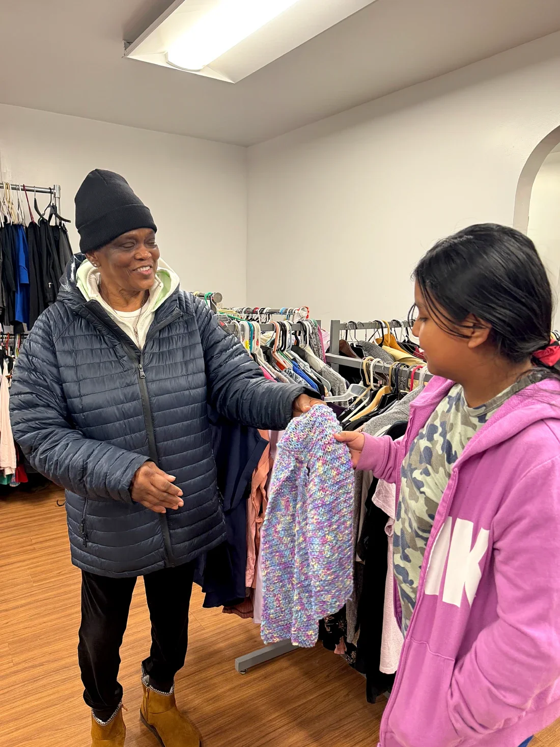 An ESWA member smiles while giving a girl a scarf