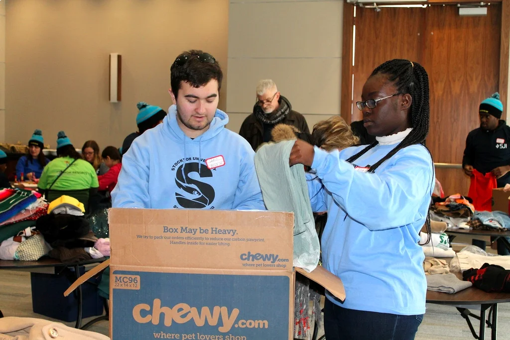 Two people sort clothing