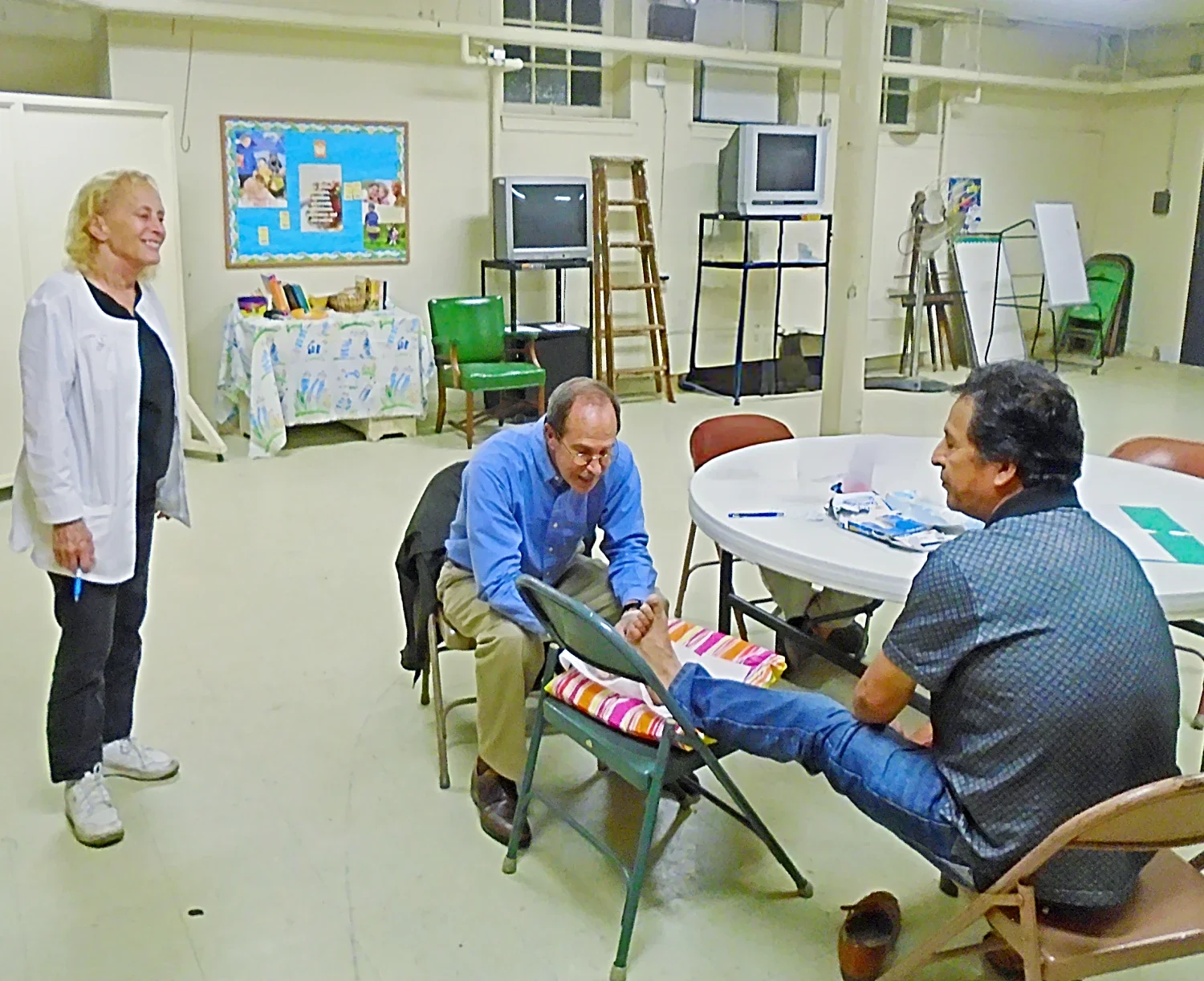 A podiatrist examines a foot while a nurse watches