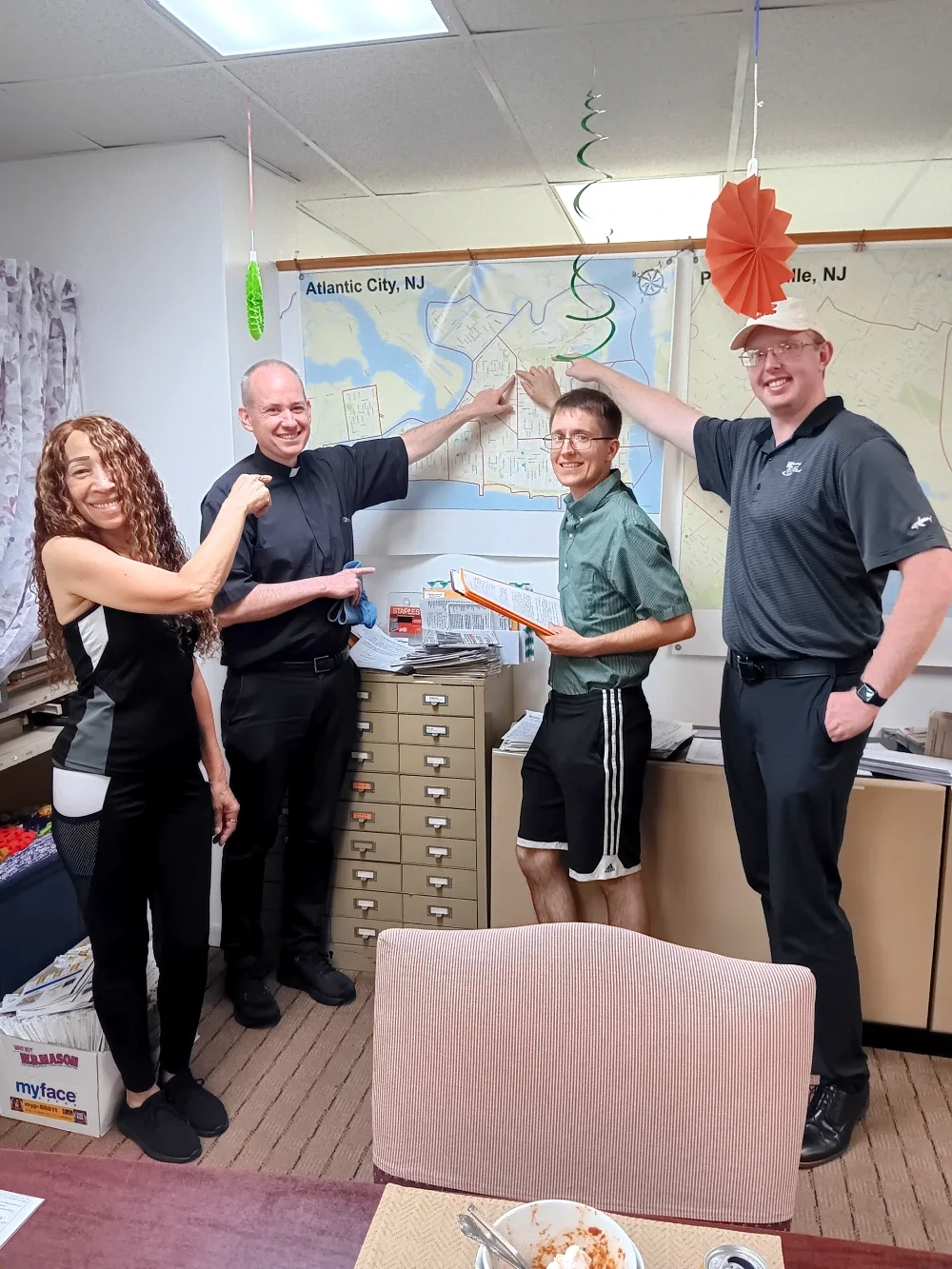 A pastor and three other people point to a map of Atlantic City
