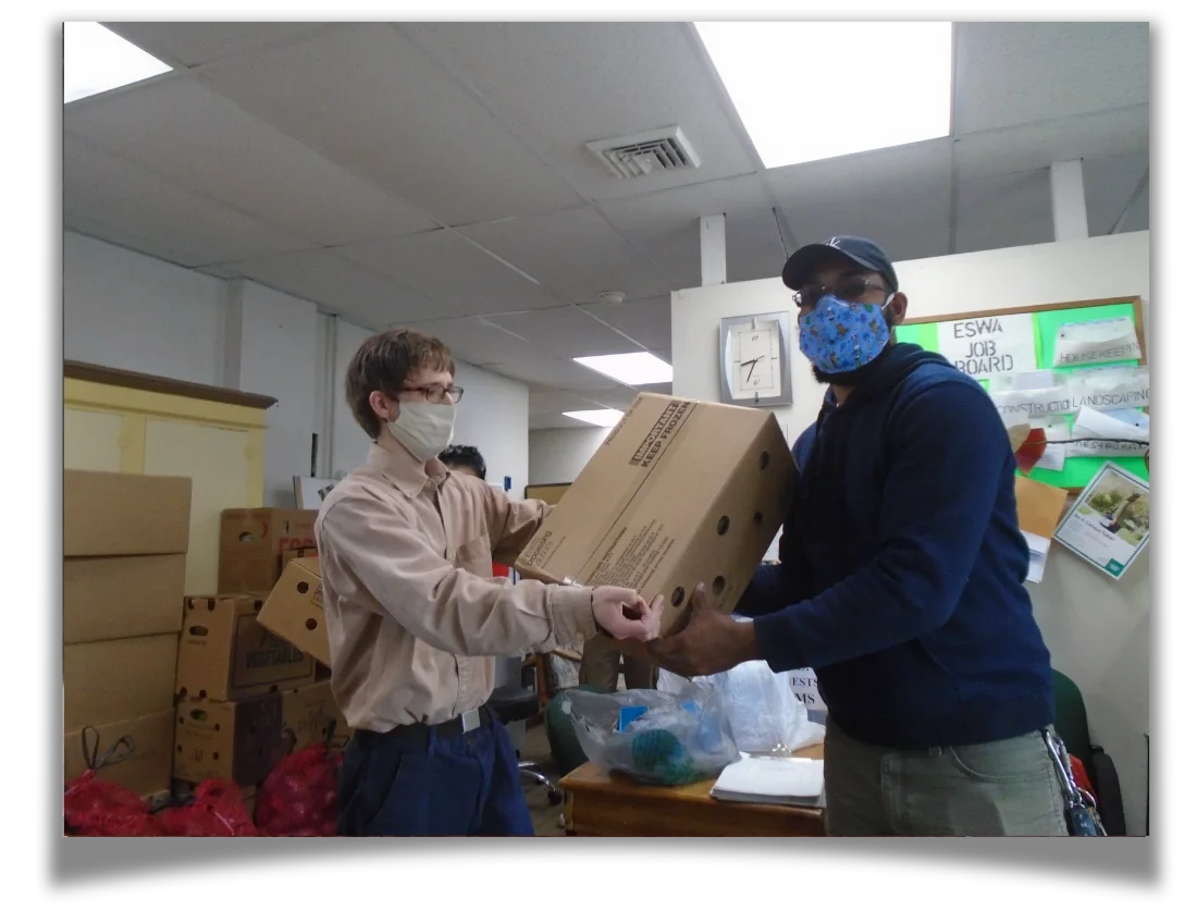 One man hands another man a box