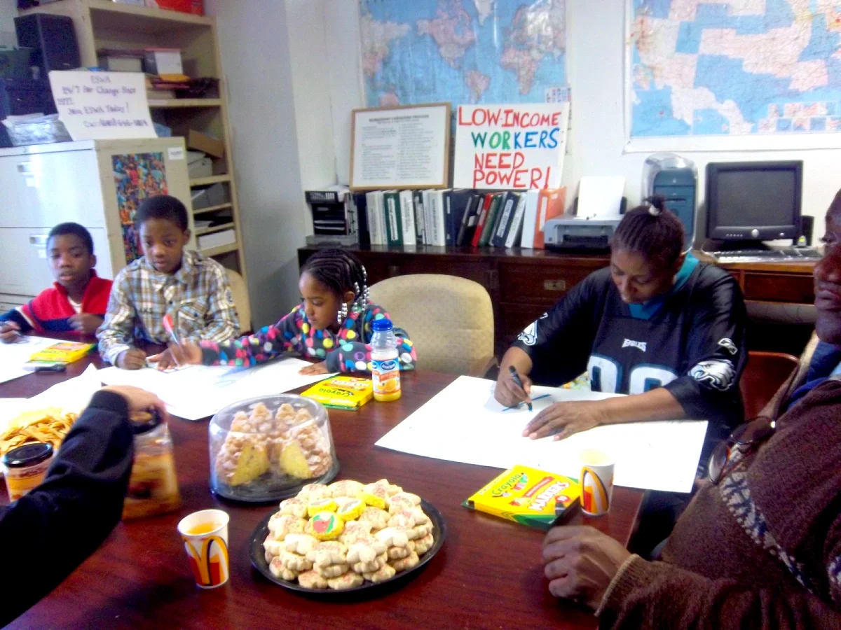 A woman and her children draw signs to hold