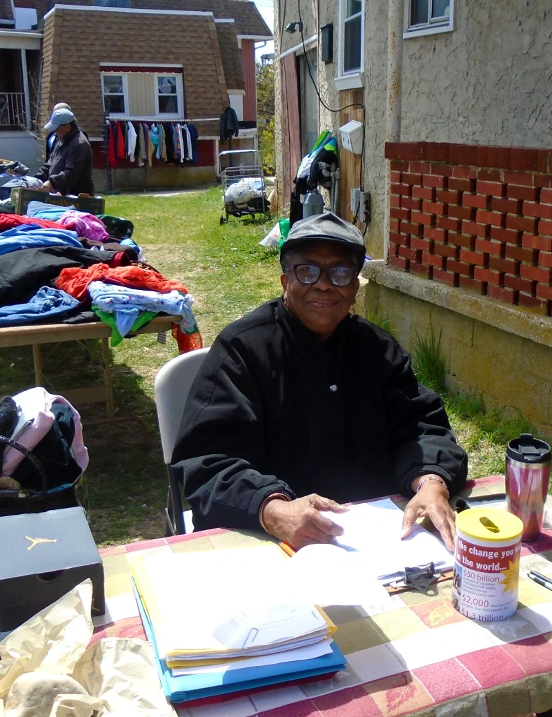 A woman greets members in front of a clothing distribution