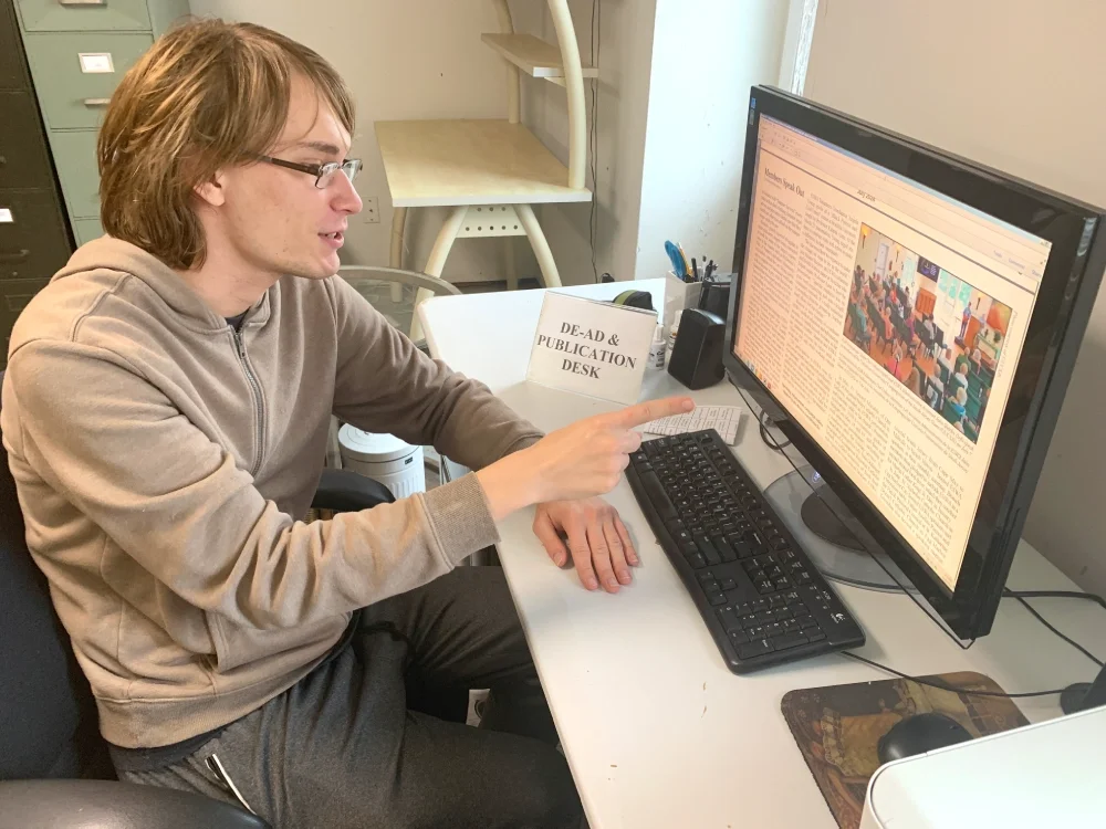 A man points to a photo on a screen