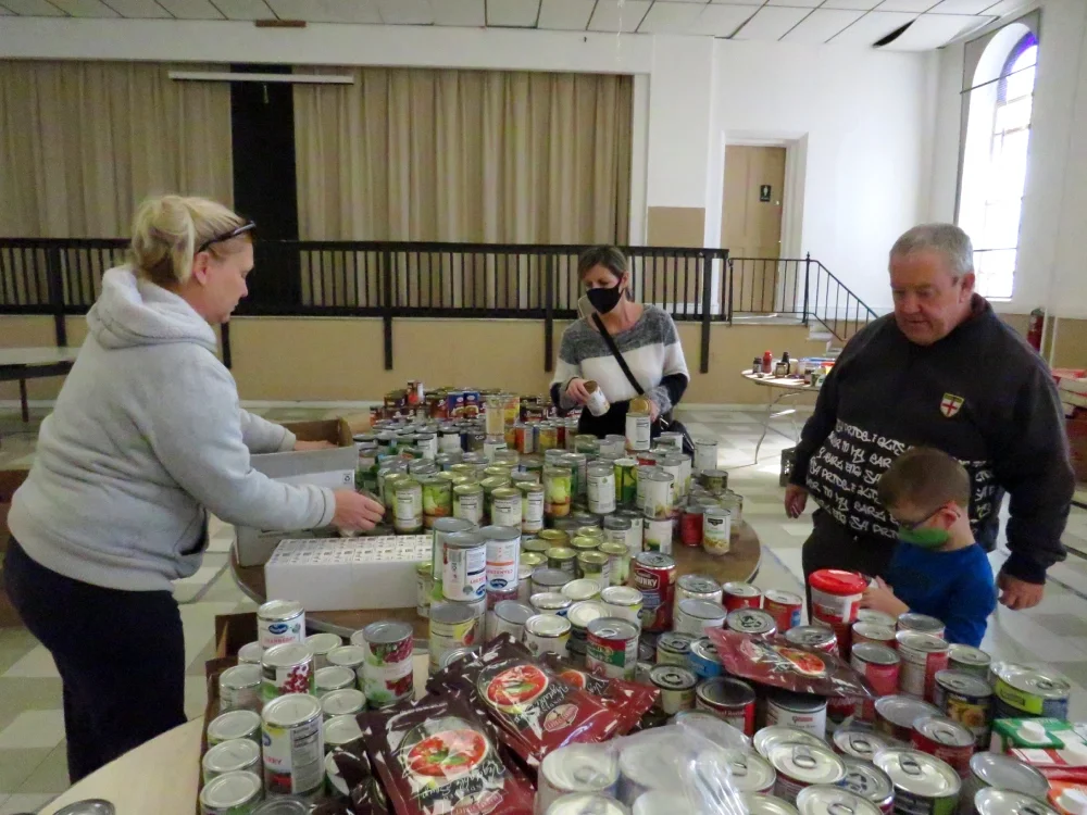 Three people sort canned food