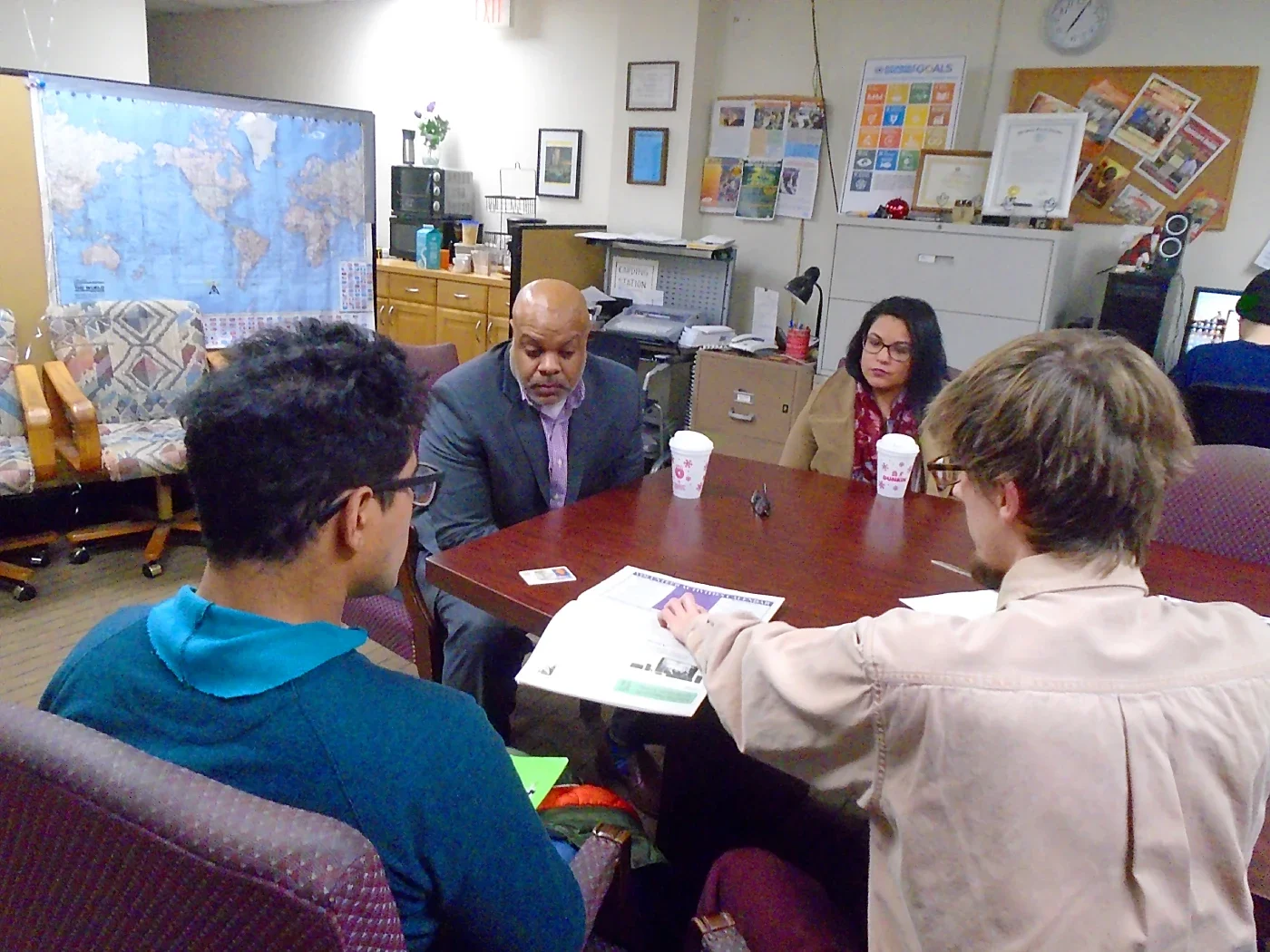 An attorney and a legal assistant behind a table speak to two people
