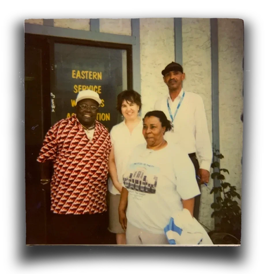 Four people pose in front of ESWA's office door