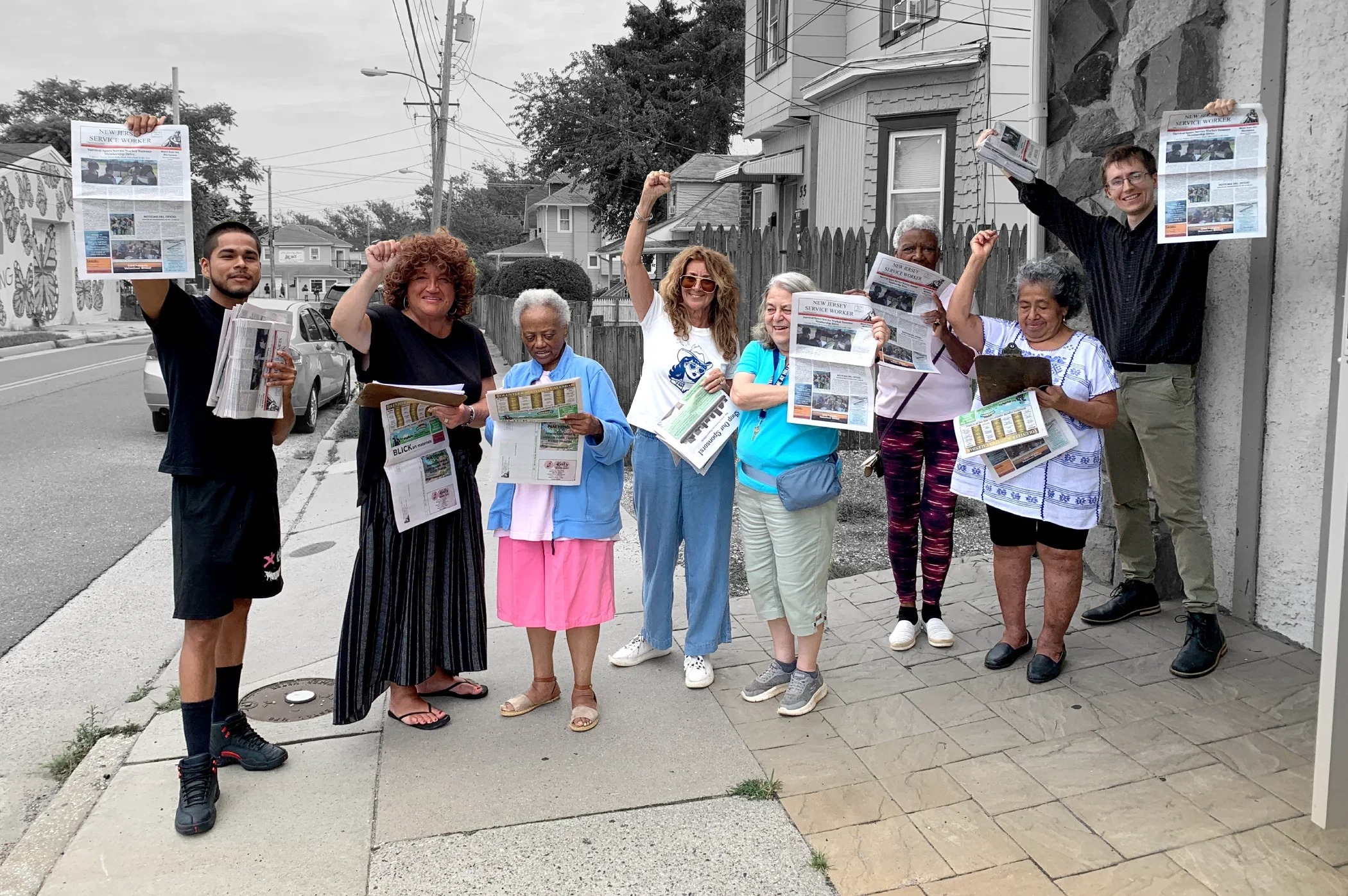 Holding newspapers, ESWA volunteers put their fists into the air