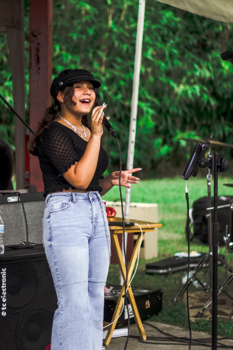 A woman sings proudly into a microphone
