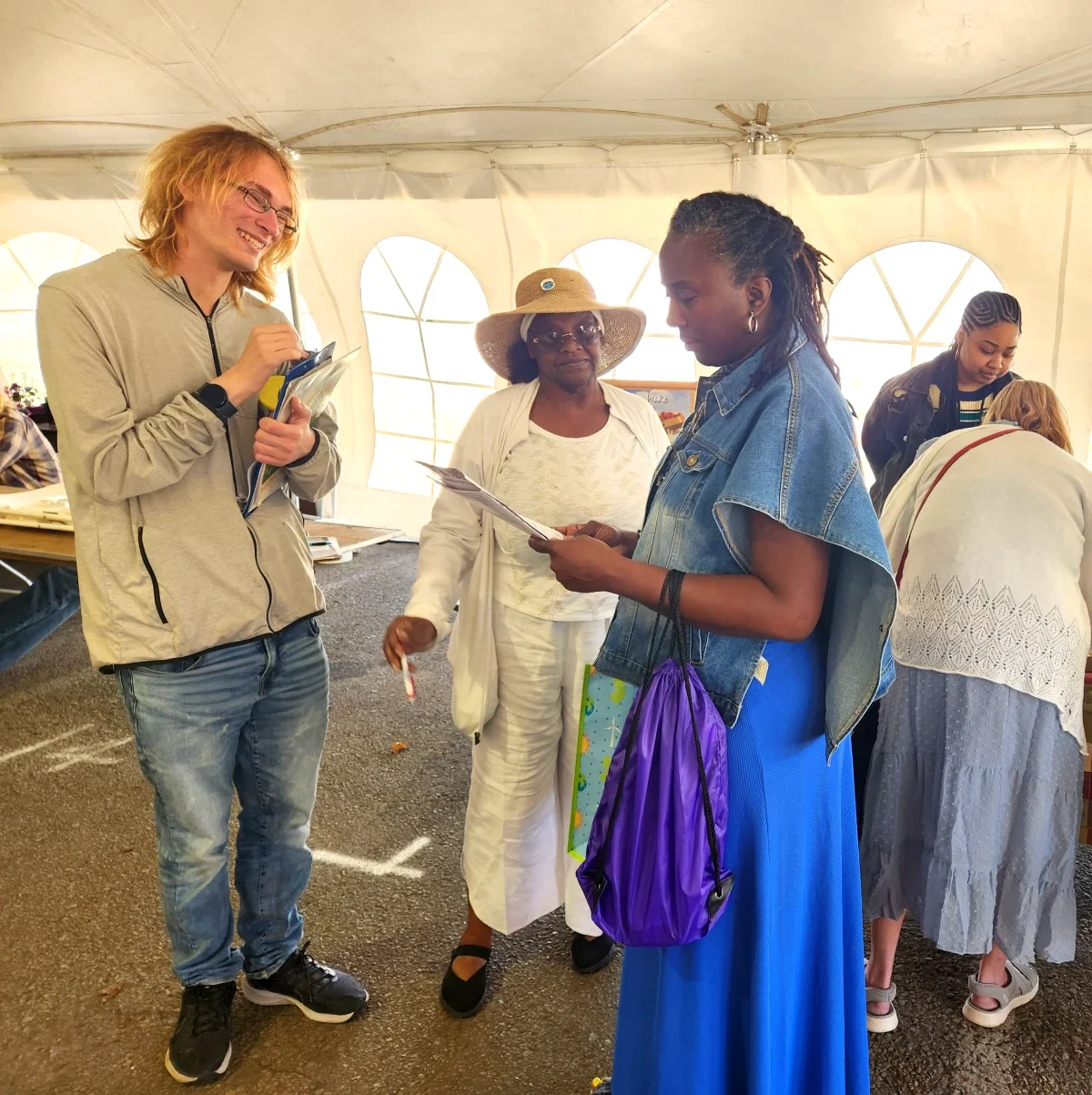 A smiling man and woman speak to a person holding an ESWA flyer