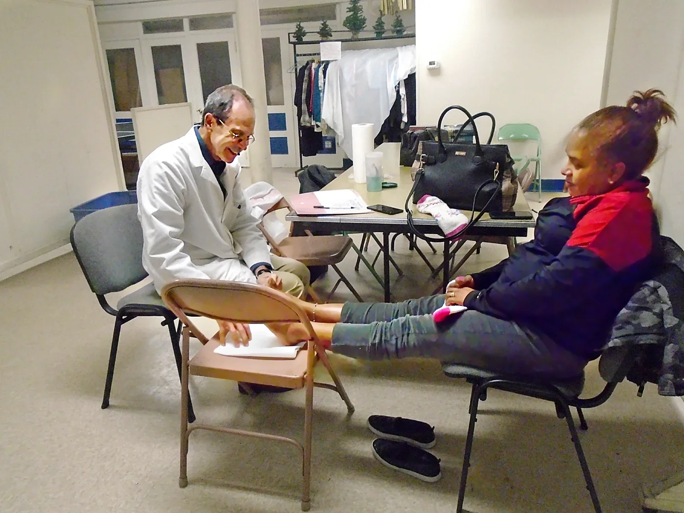 A podiatrist smiles while working with a patient