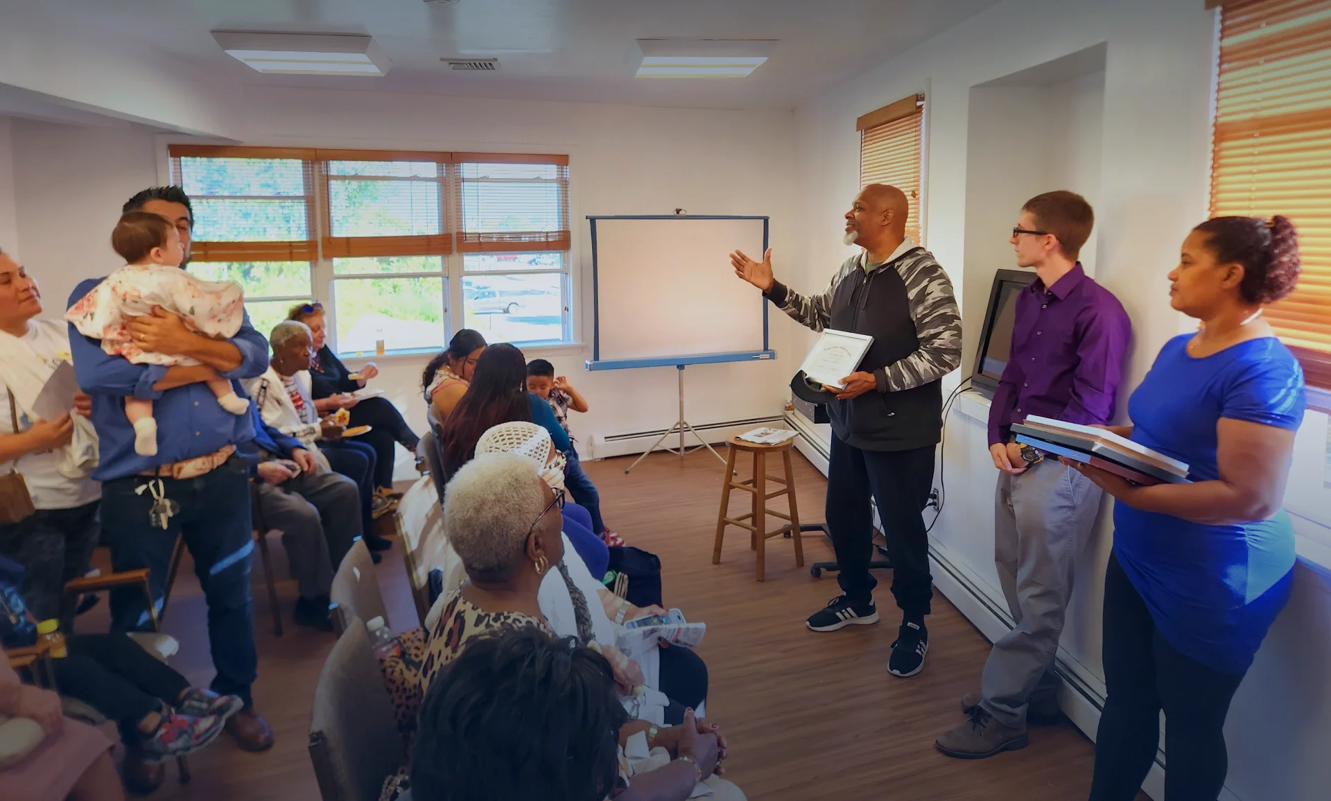 Man addresses a crowd at ESWA's Benefit Office.