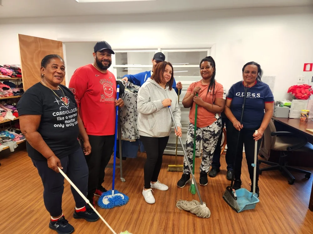ESWA members with brooms and dustpans pose for a photo