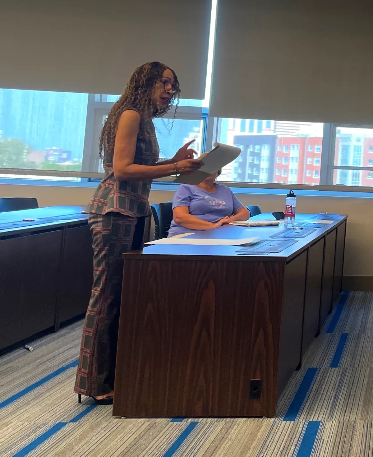 a woman with a clipboard speaks