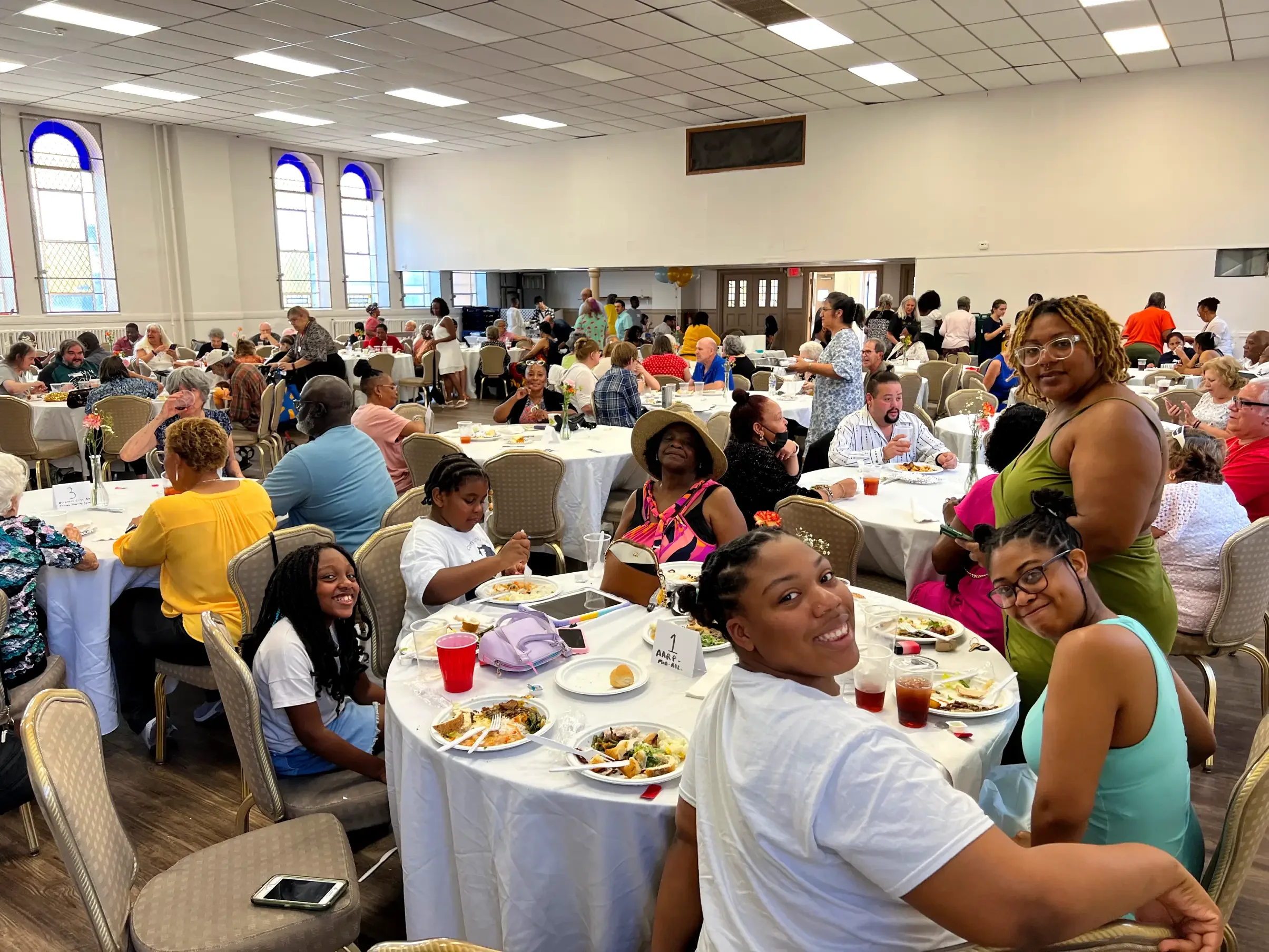 At a crowded event, a family smiles for a photo