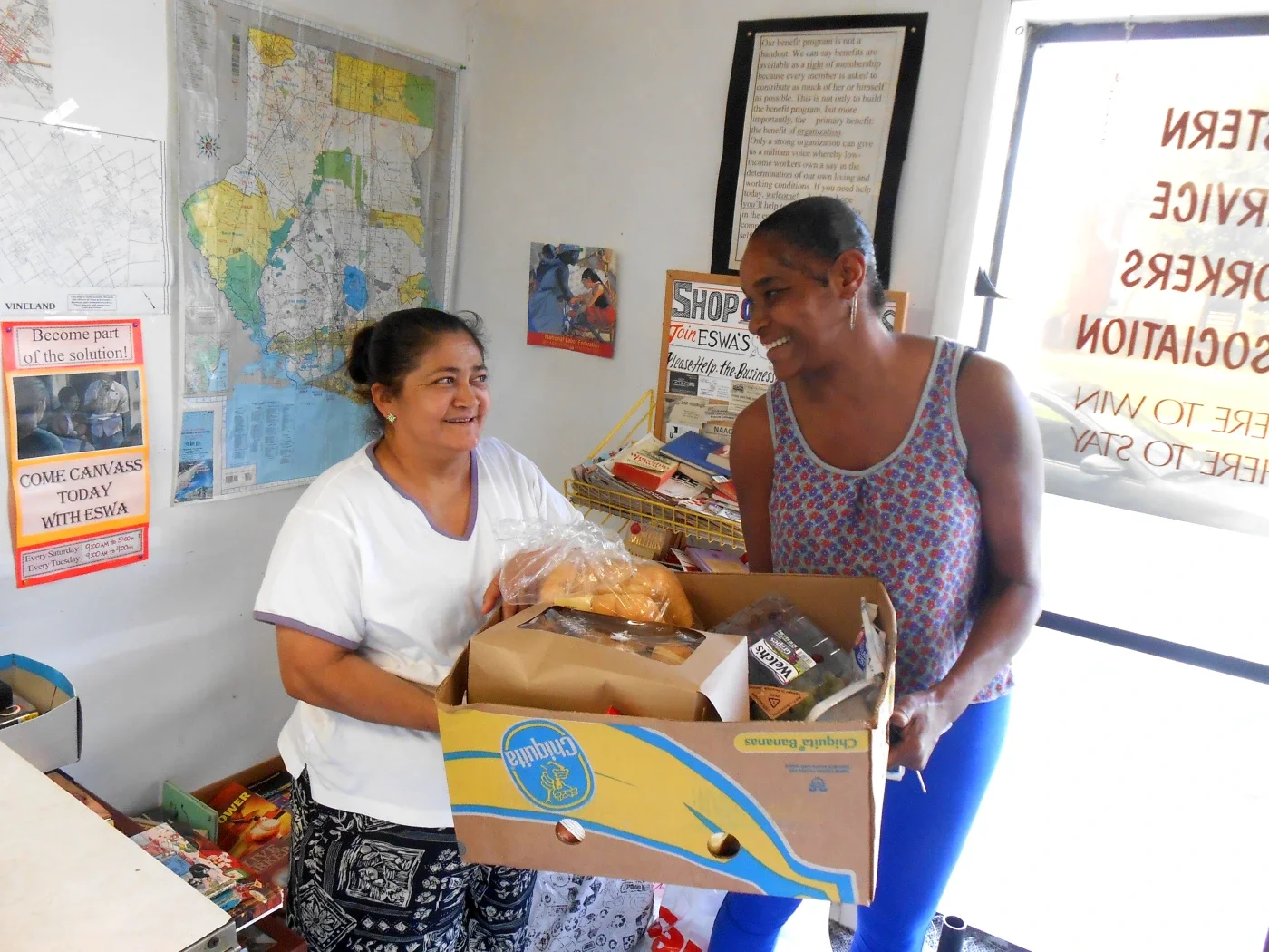 A volunteer passes a box of food to a requesting member